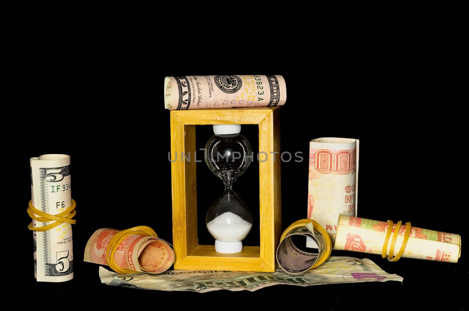 Buisness Time Concept Hourglass and Money on a Black Background