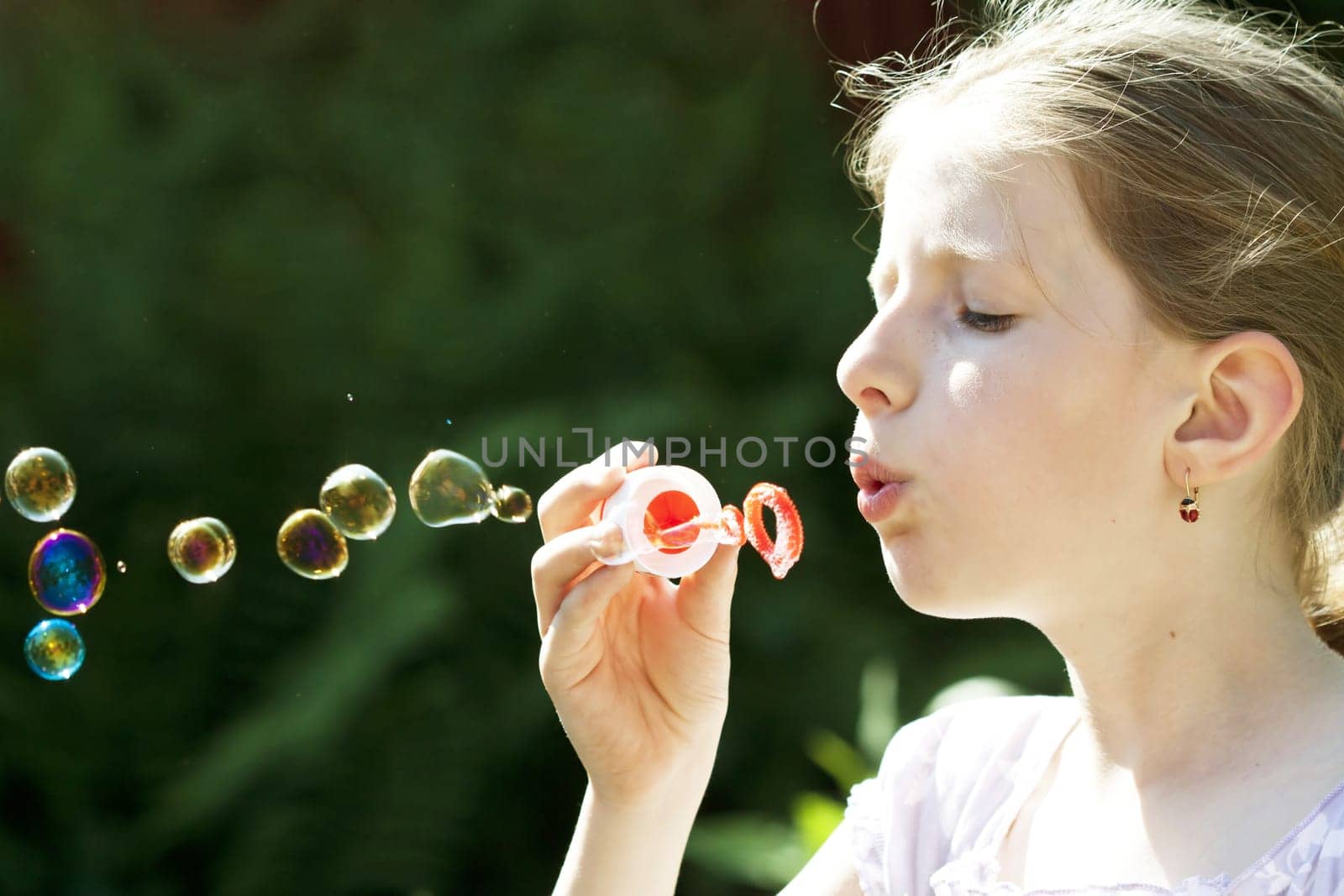 Retro styled photo of young girl blowing soap bubbles