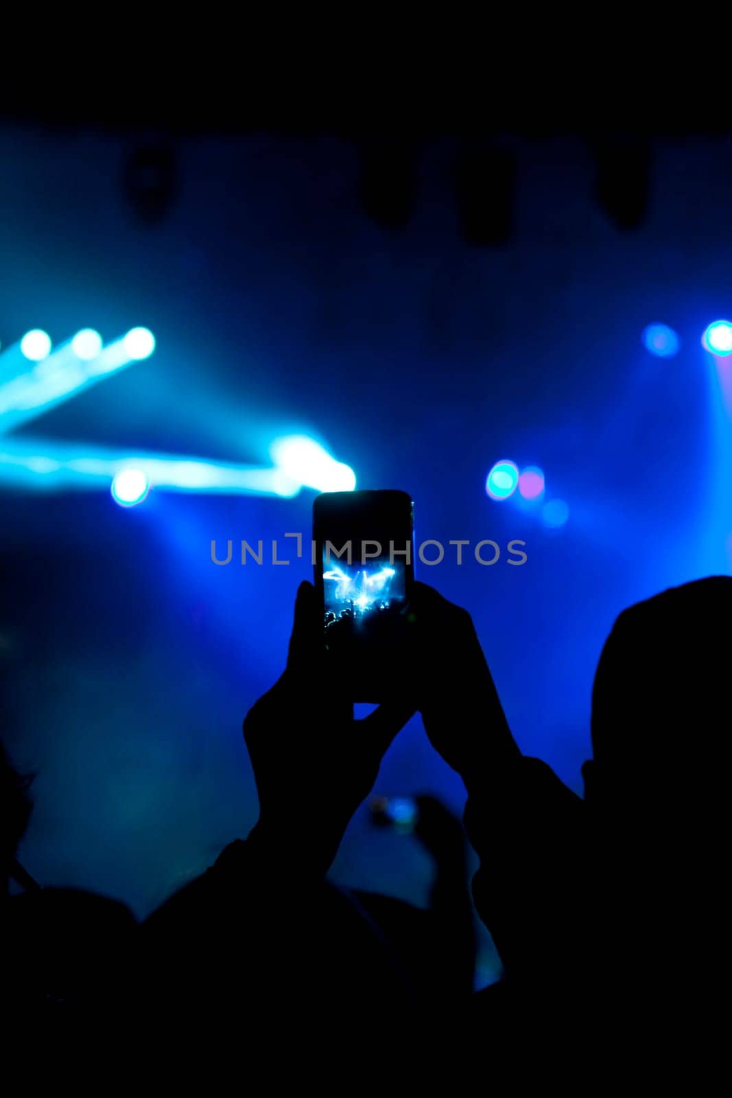 Cheering crowd in front of bright colorful stage lights