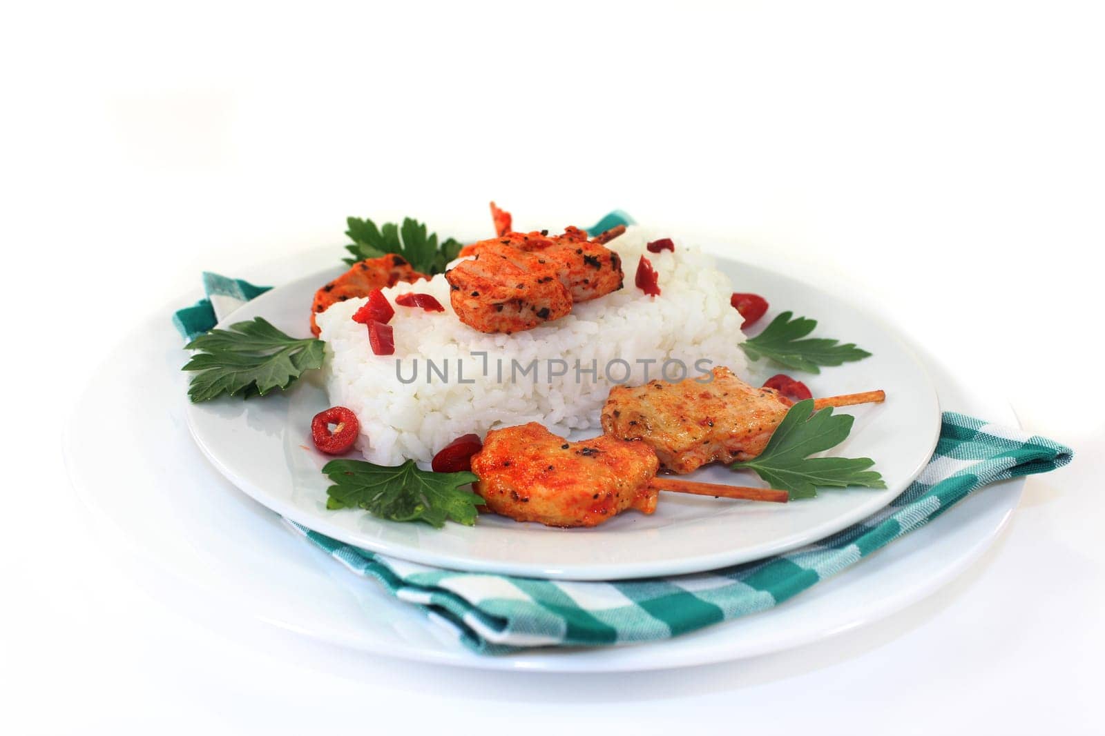 Meat skewer with rice and pepperoni on a white plate