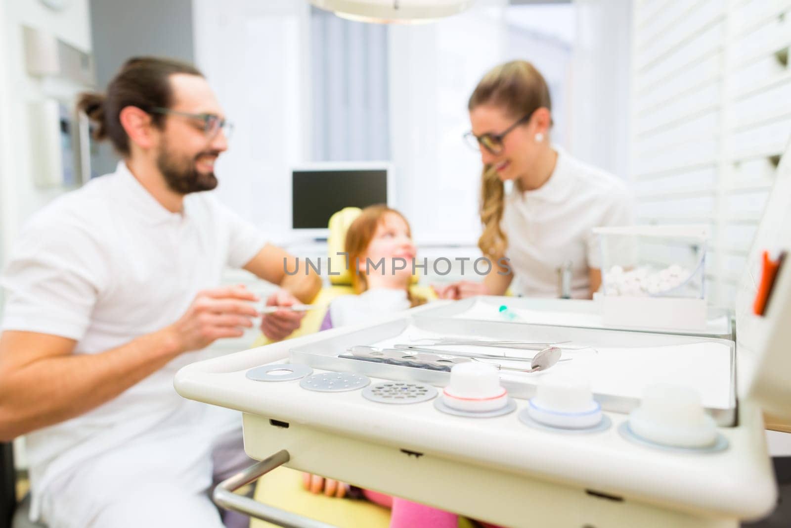 Dentist giving girl treatment  in dental surgery