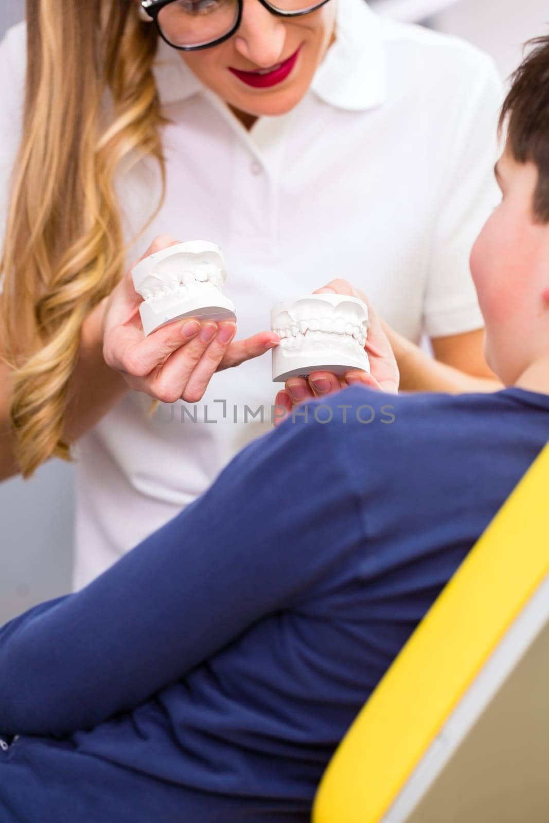 Female Orthodontist explaining boy braces