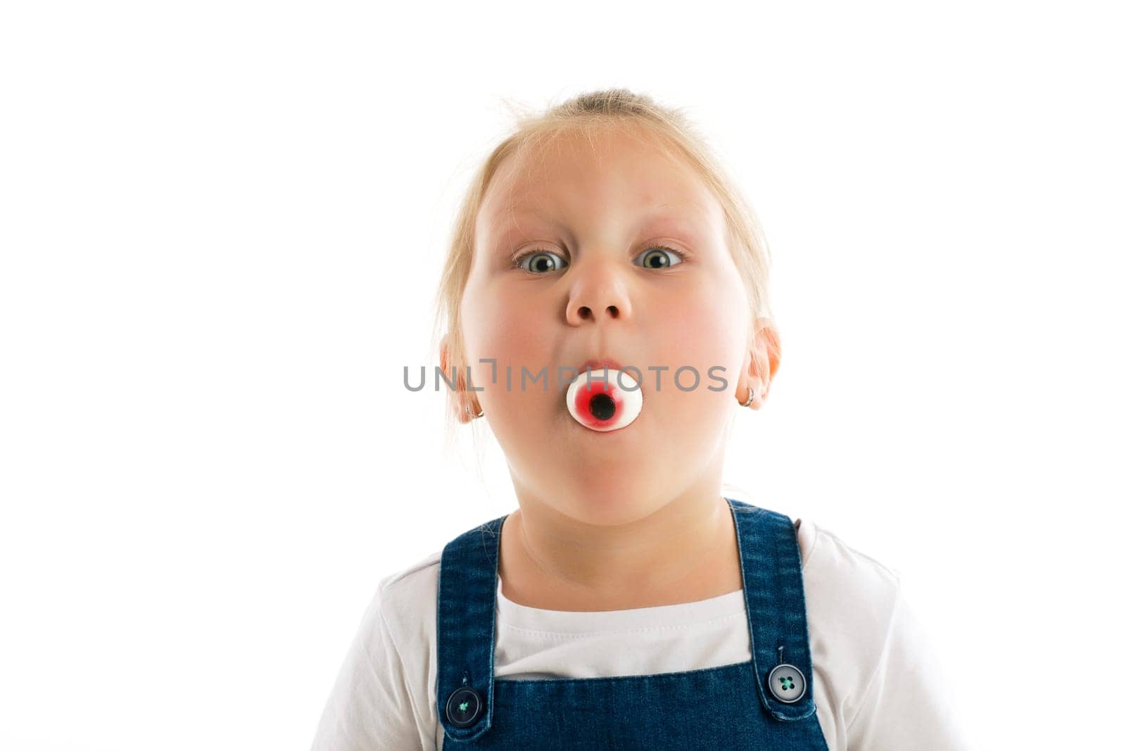 little girl with eye in her mouth. studio shot