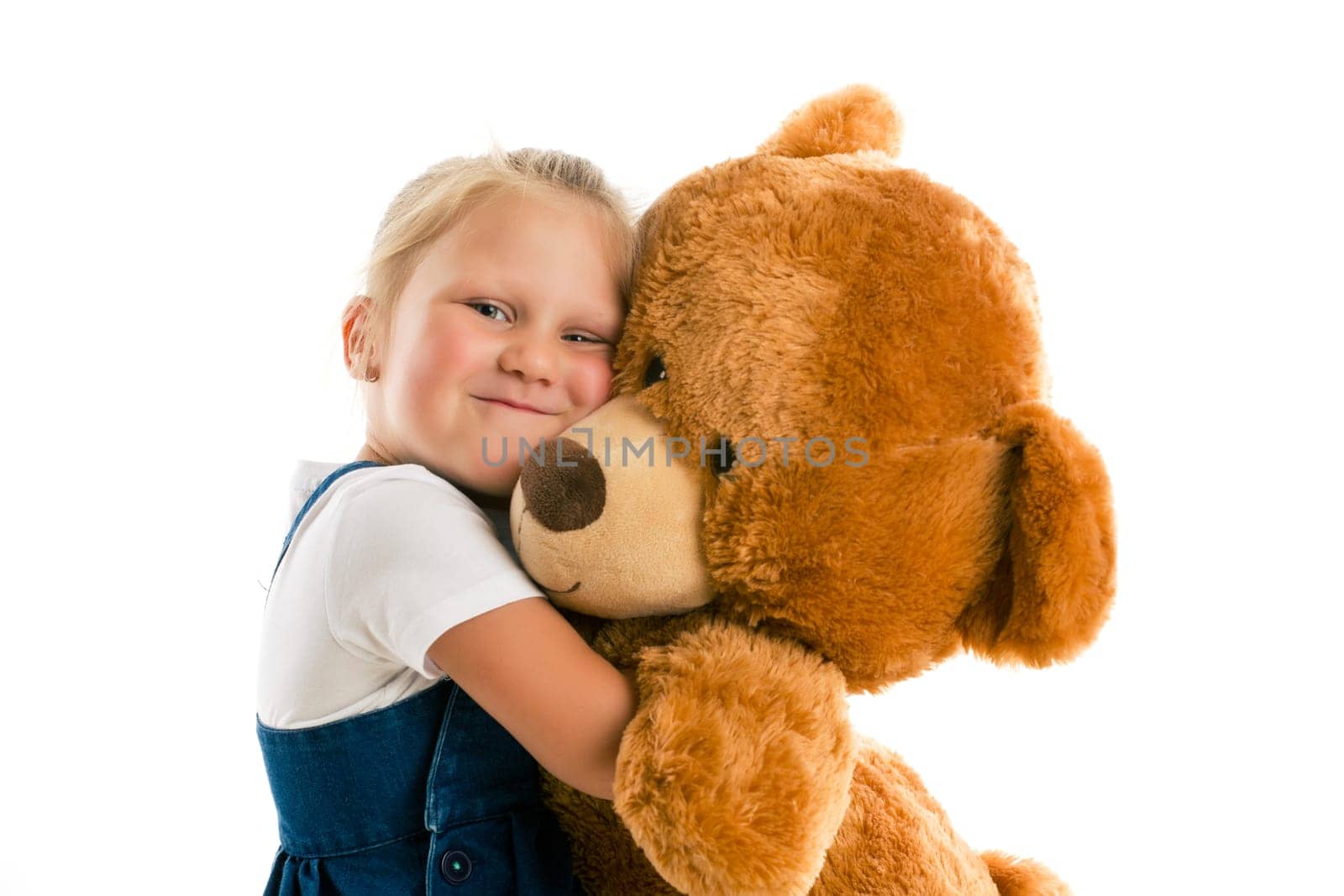 little girl with big teddy bear. studio shot
