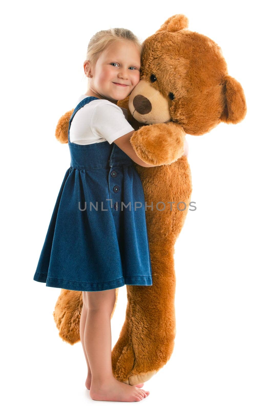 little girl with big teddy bear. studio shot