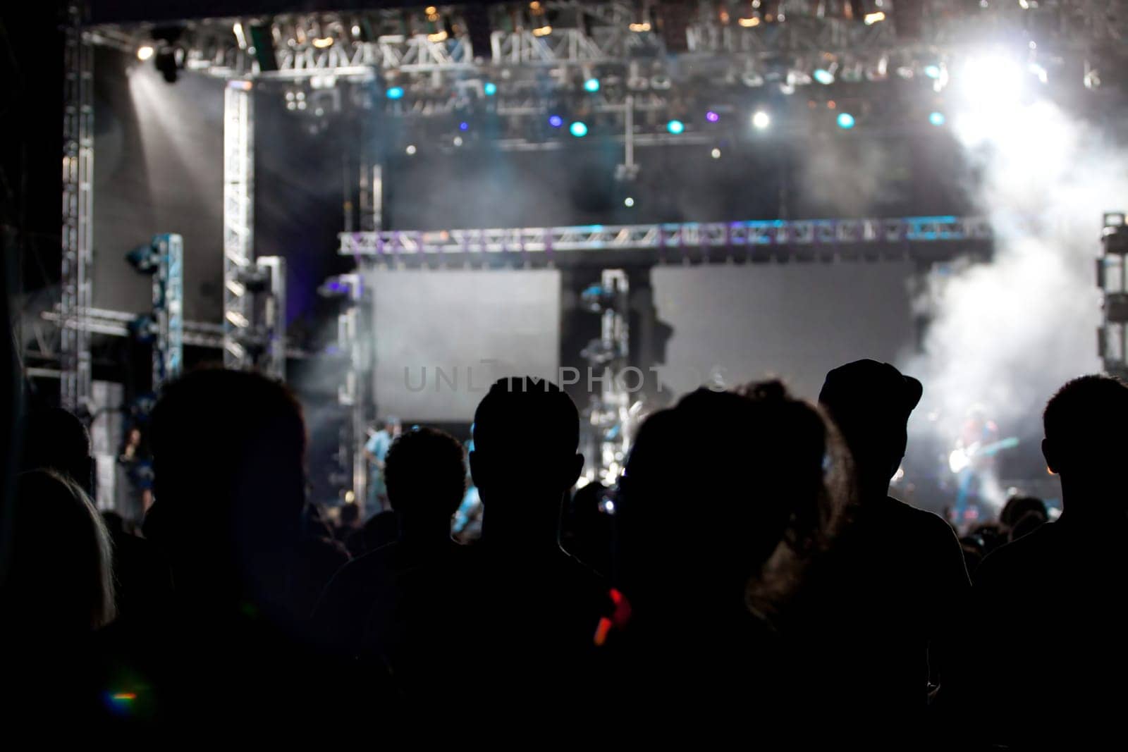 Cheering crowd in front of bright colorful stage lights