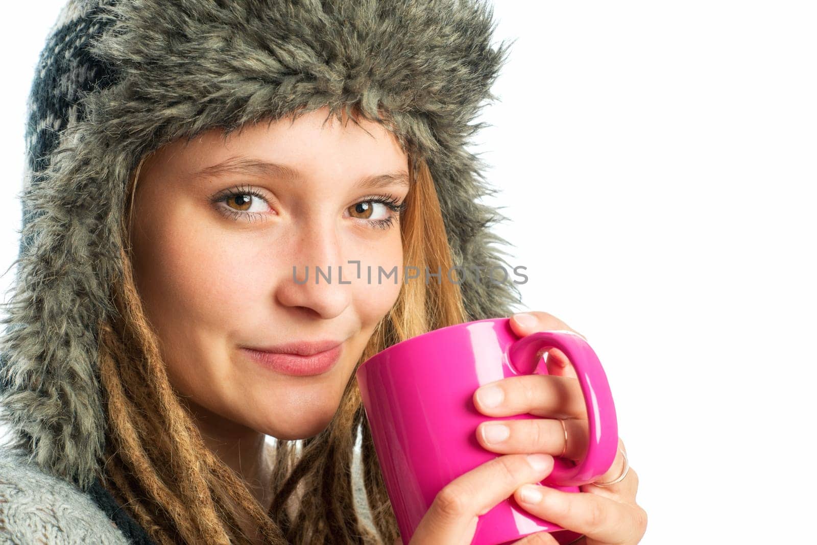 Blonde girl with fur hat holds coffee mug