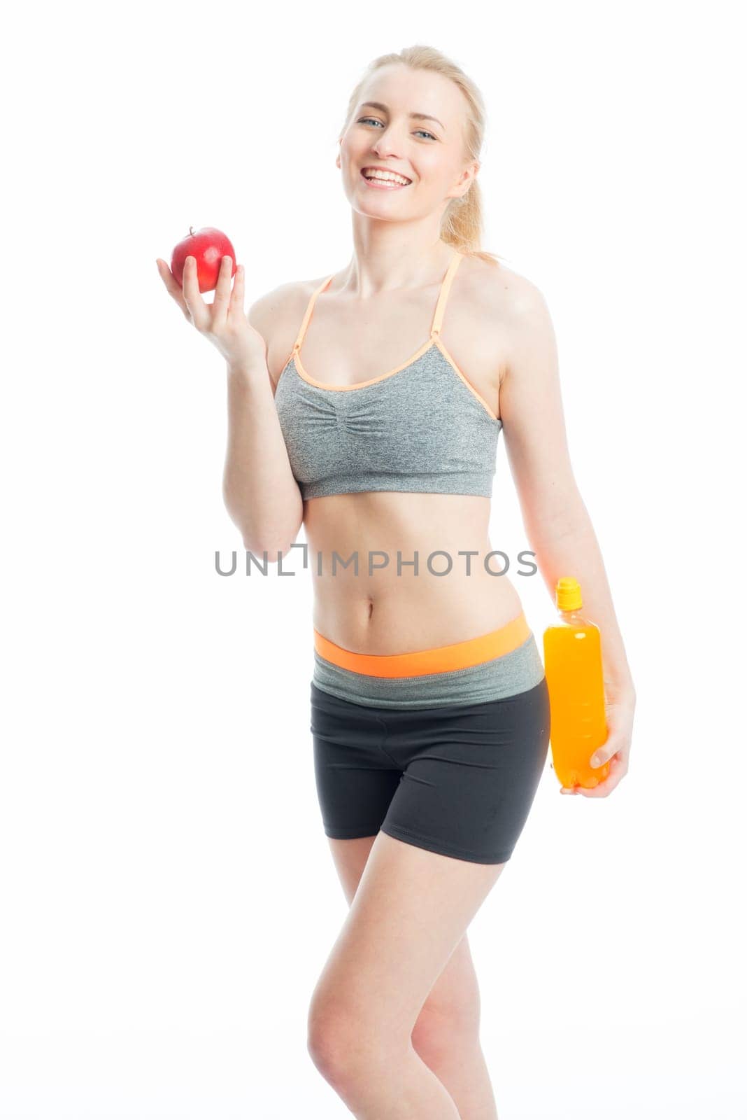 Blonde sportswoman with drink and apple