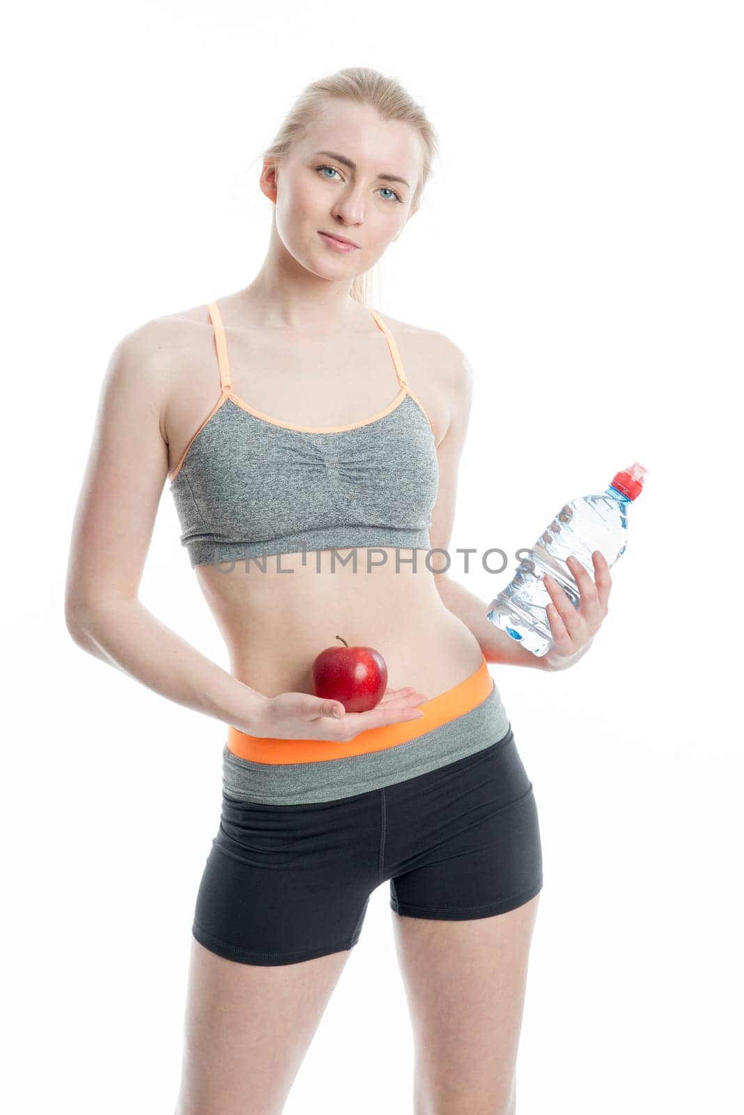 Blonde sportswoman with drink and apple