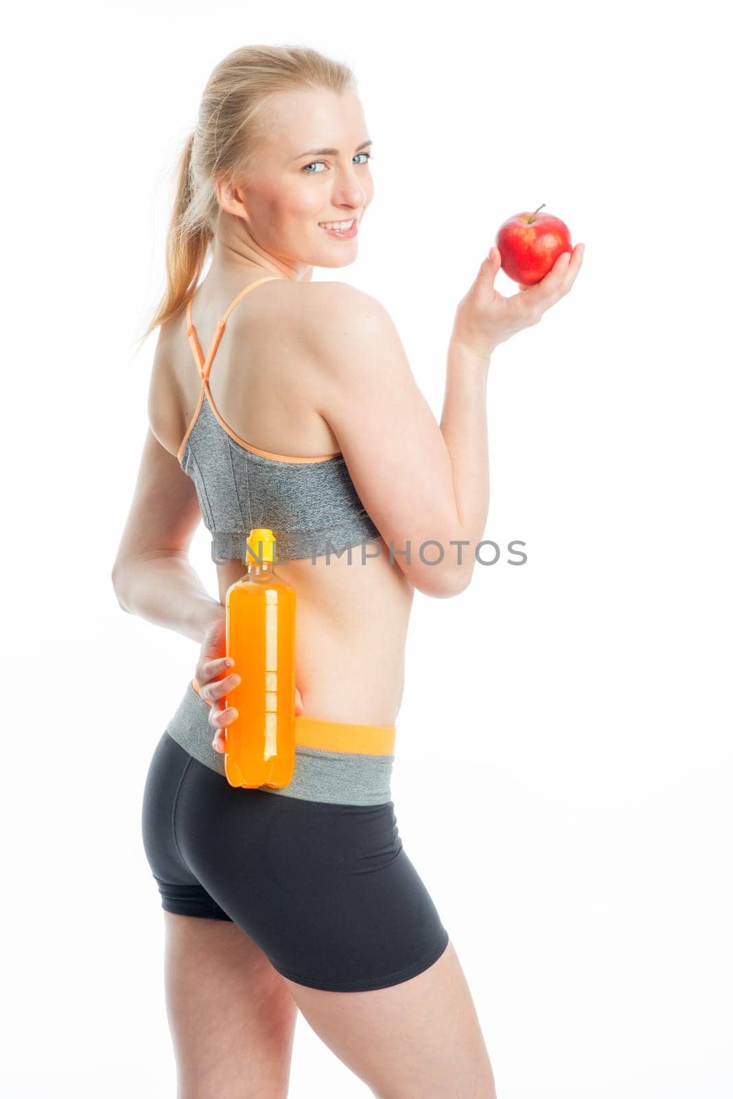 Blonde sportswoman with drink and apple