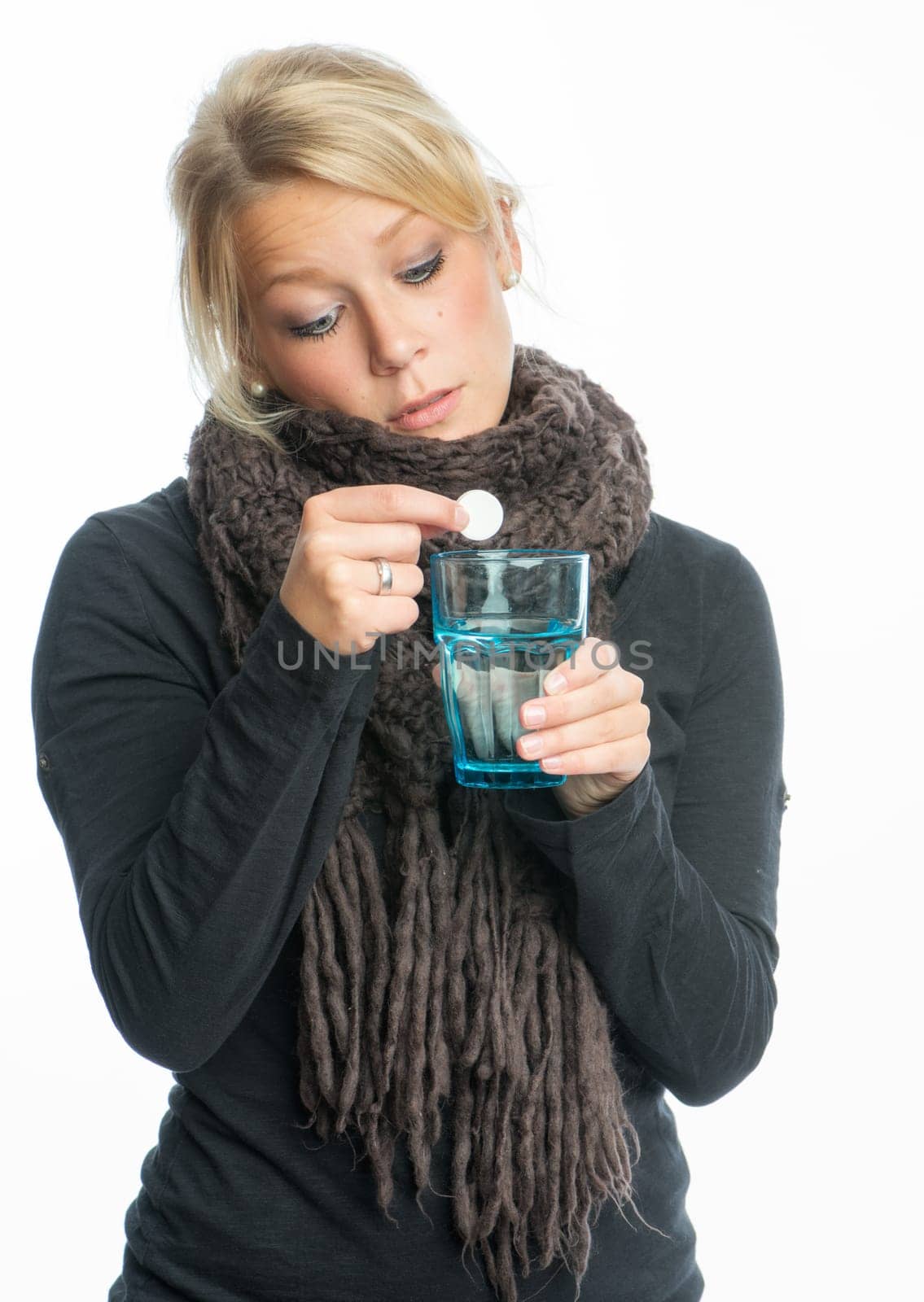 Sick blonde woman dissolves effervescent tablet in water