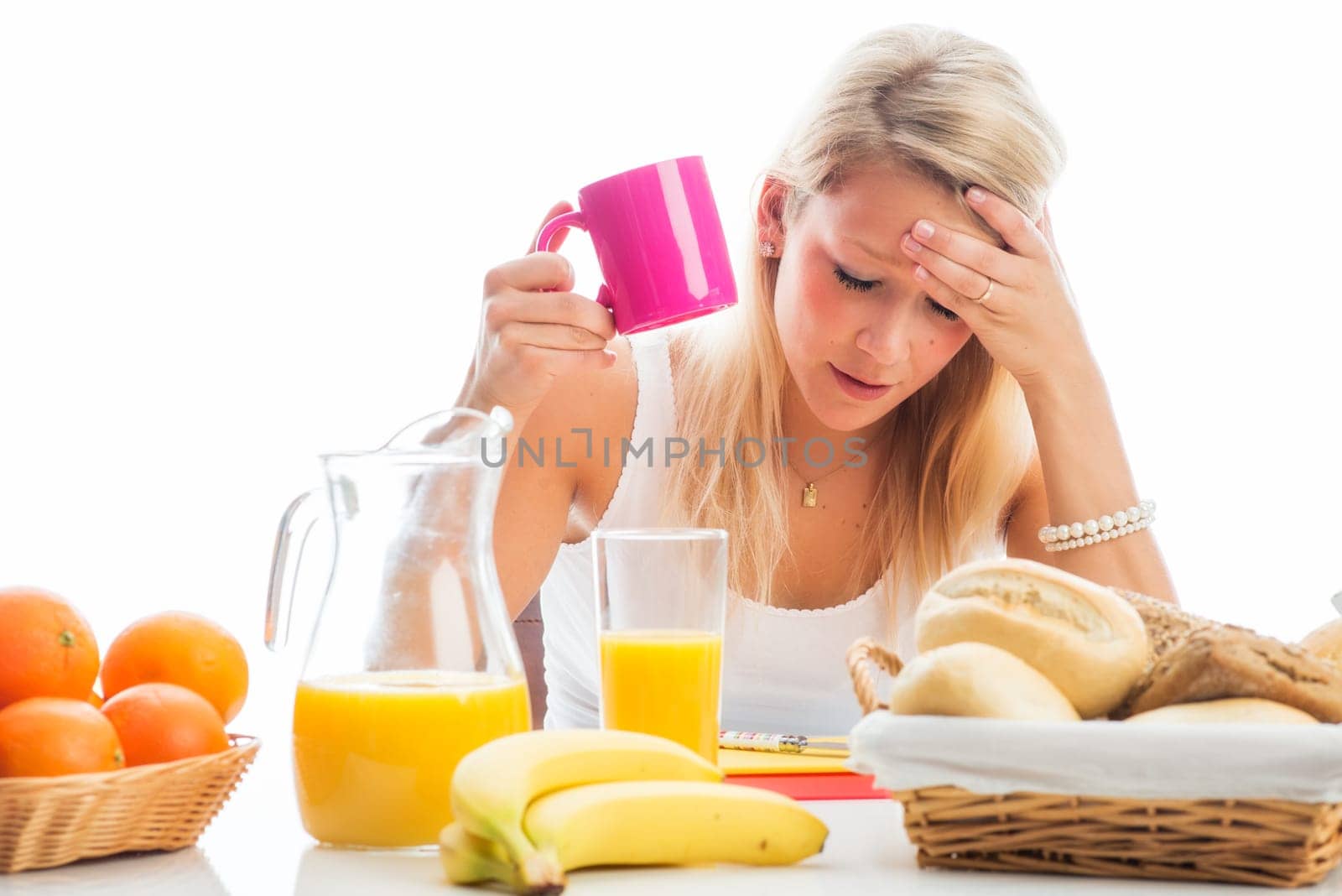 Blonde woman sits at the covered breakfast table