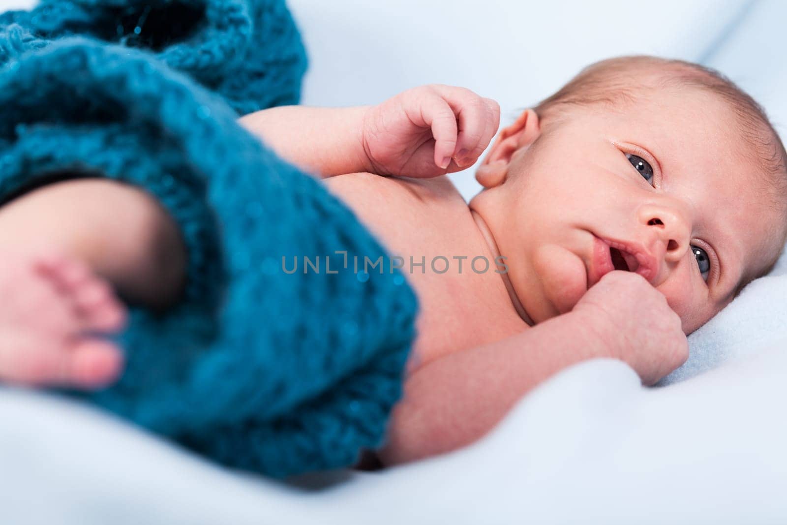Newborn baby wrapped in a scarf sleeps naked as a close-up