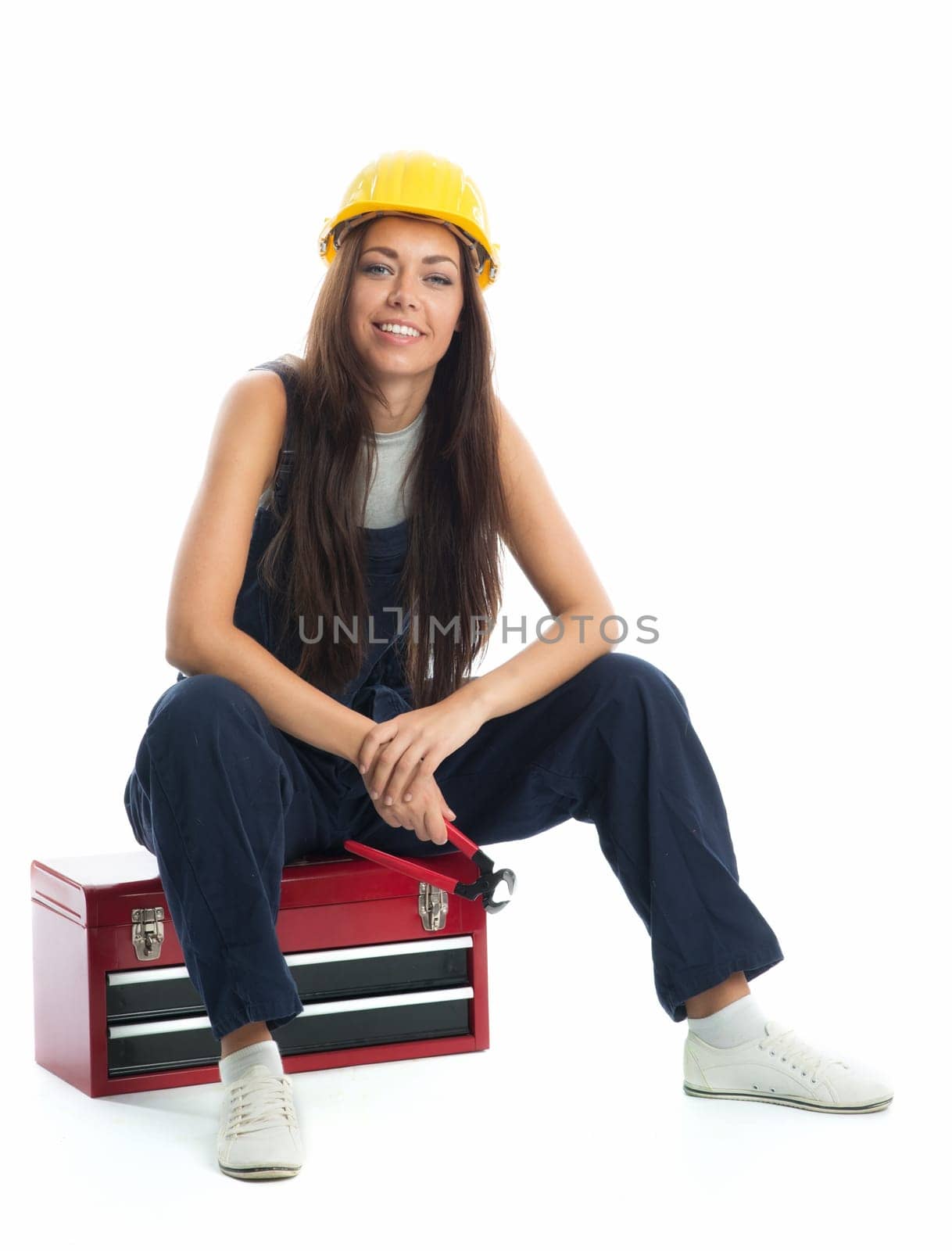 Female apprentice sits on toolbox