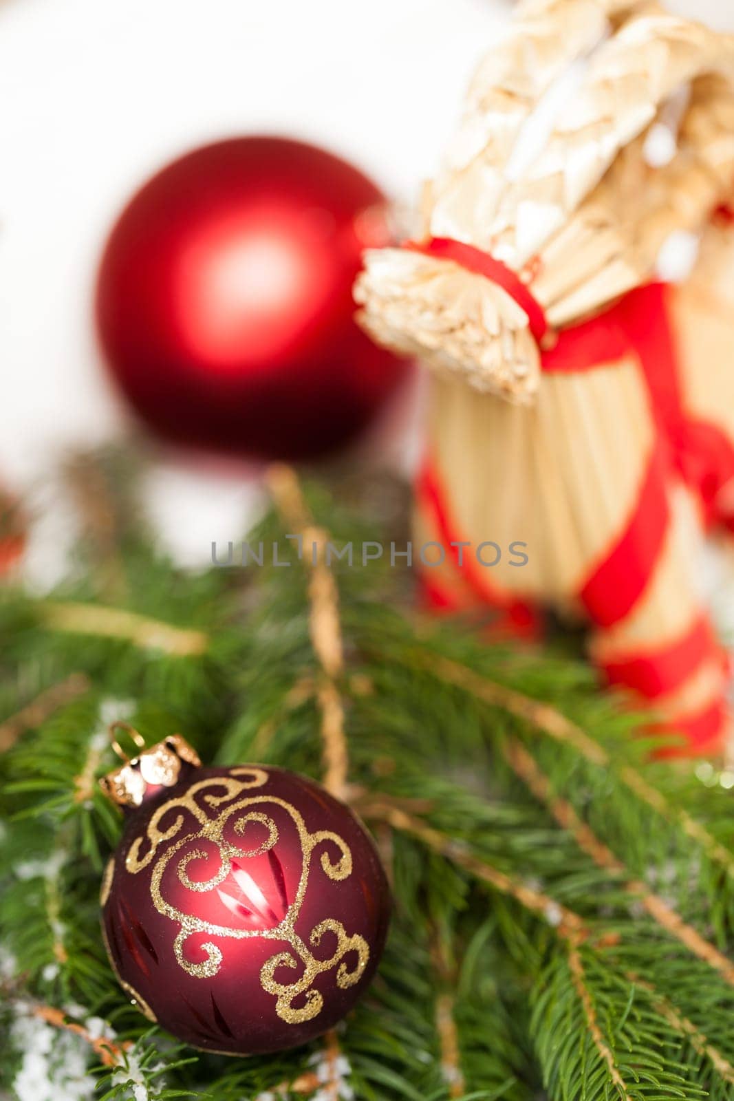 Decoration for Christmas with red and gold Christmas tree balls in front of green fir branches in the background
