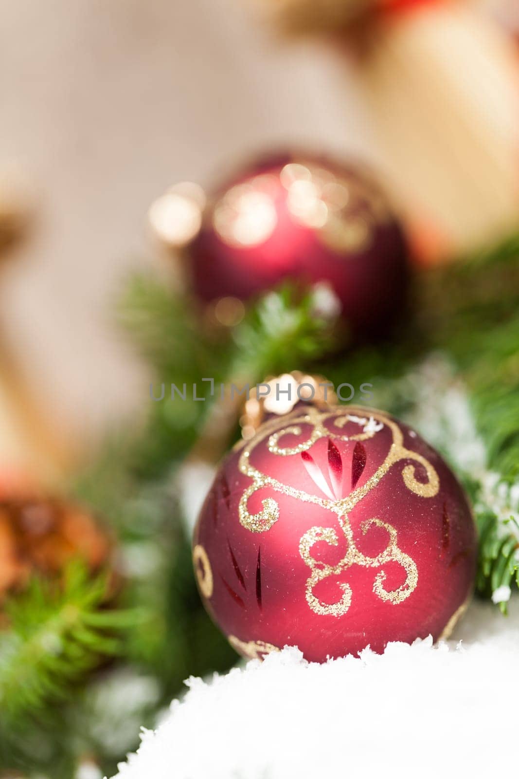 Decoration for Christmas with red and gold Christmas tree balls in front of green fir branches in the background