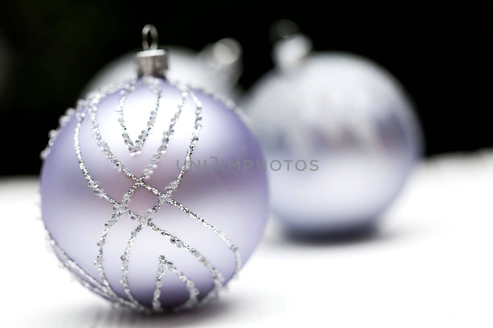 Glittering silver Christmas bauble on white background Macro detail