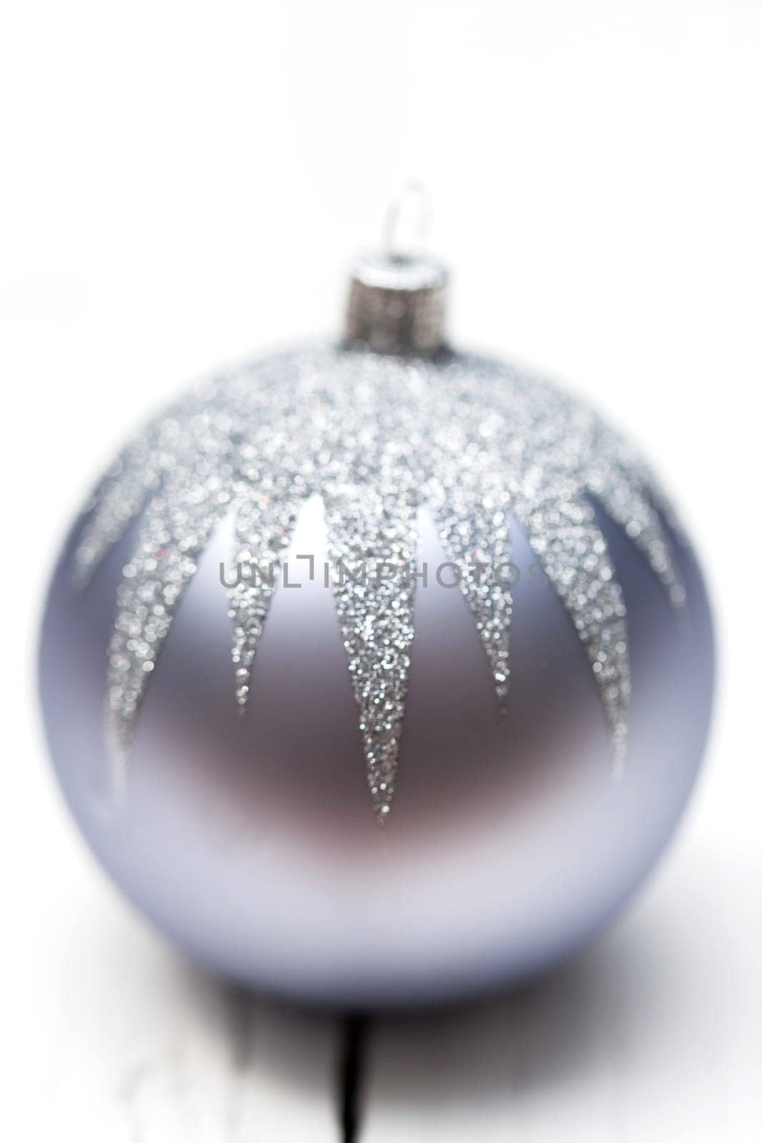 Glittering silver Christmas bauble on white background Macro detail