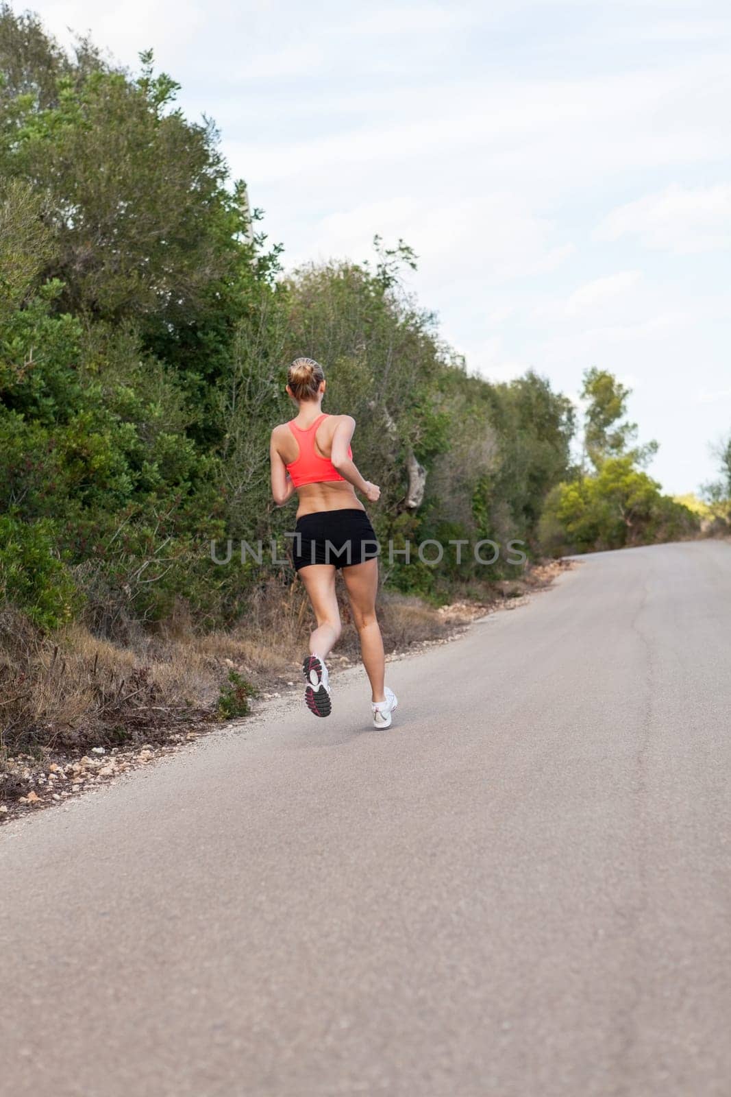 attractive sporty young woman jogging on an outdoor street in daylight