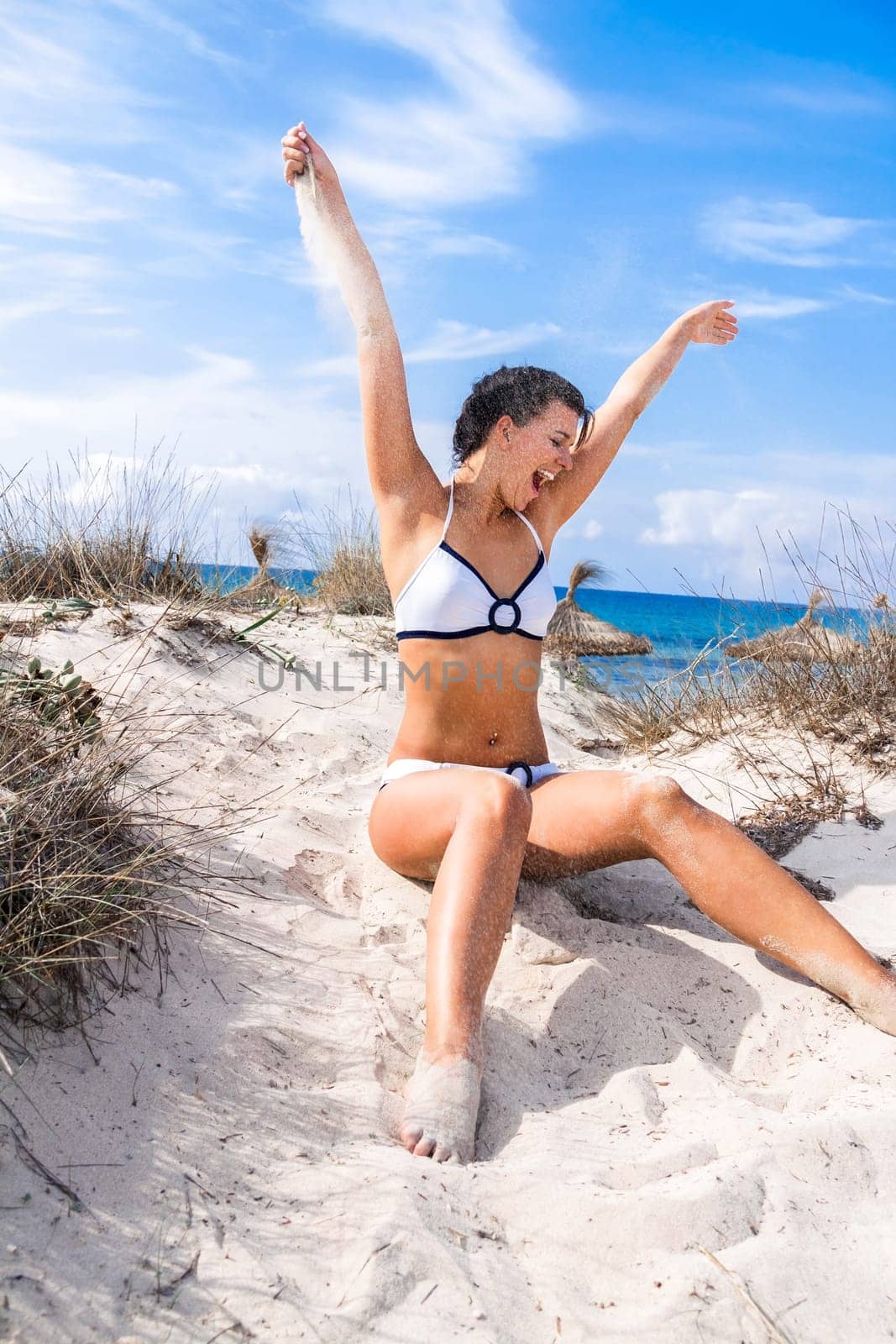 Young attractive woman in bikini in summer on the beach on vacation with blue hommel