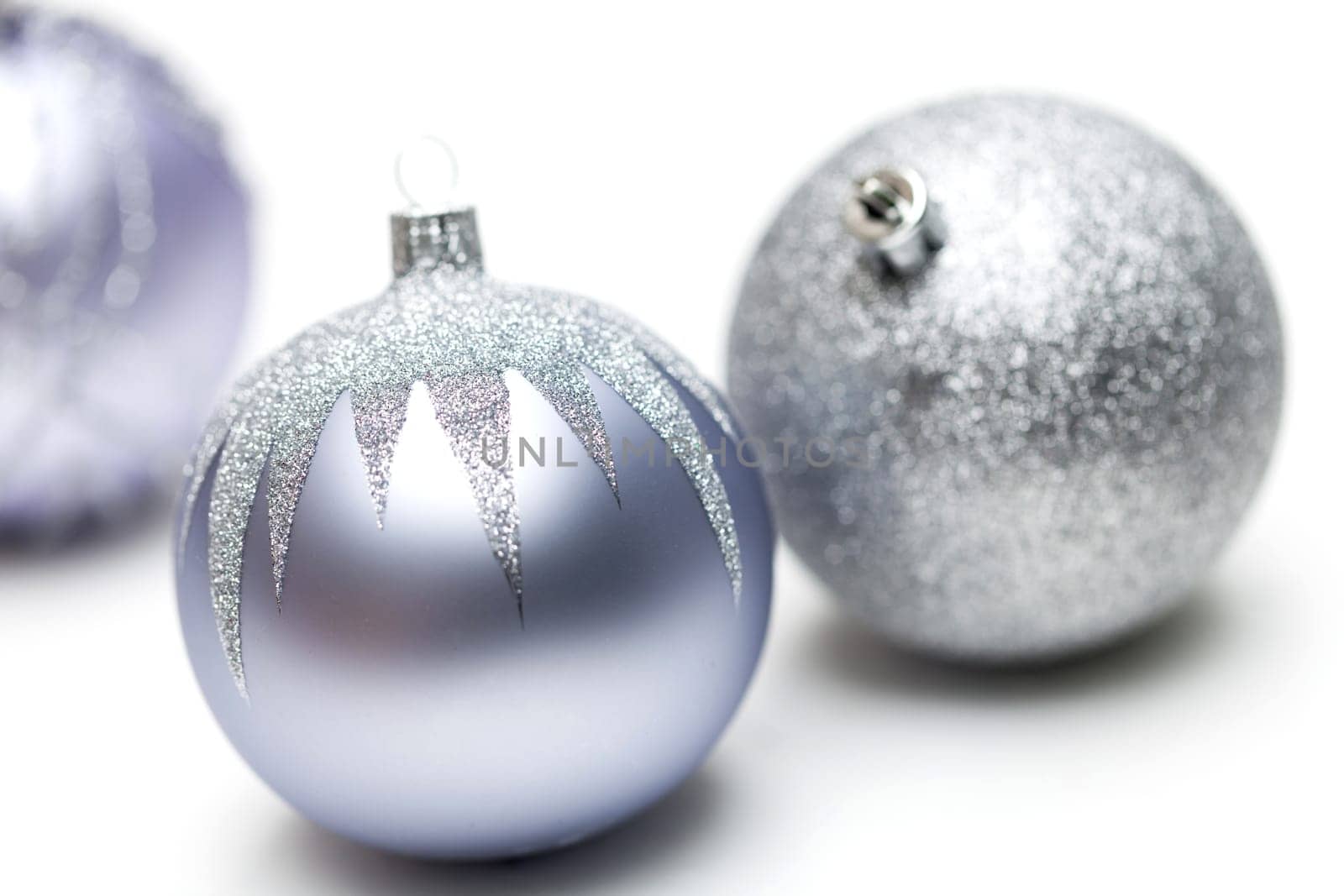 Glittering silver Christmas bauble on white background Macro detail