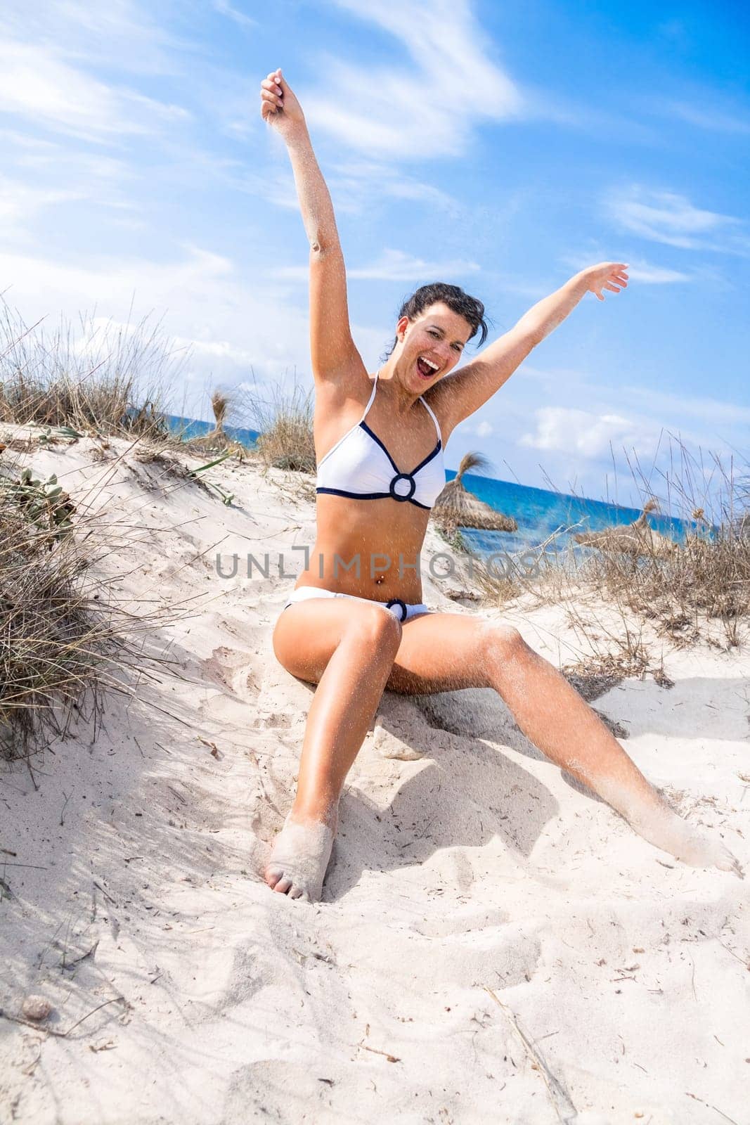 Young attractive woman in bikini in summer on the beach on vacation with blue hommel