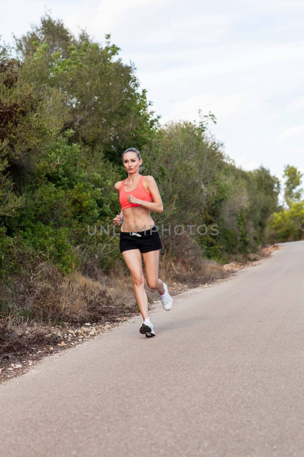 attractive sporty young woman jogging on an outdoor street in daylight