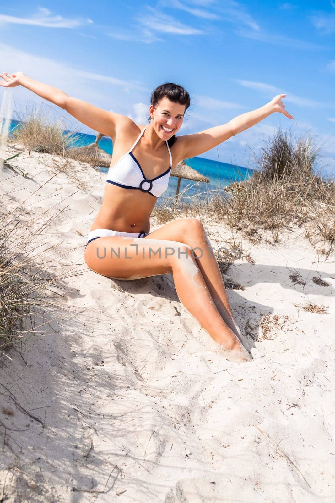 Young attractive woman in bikini in summer on the beach on vacation with blue hommel