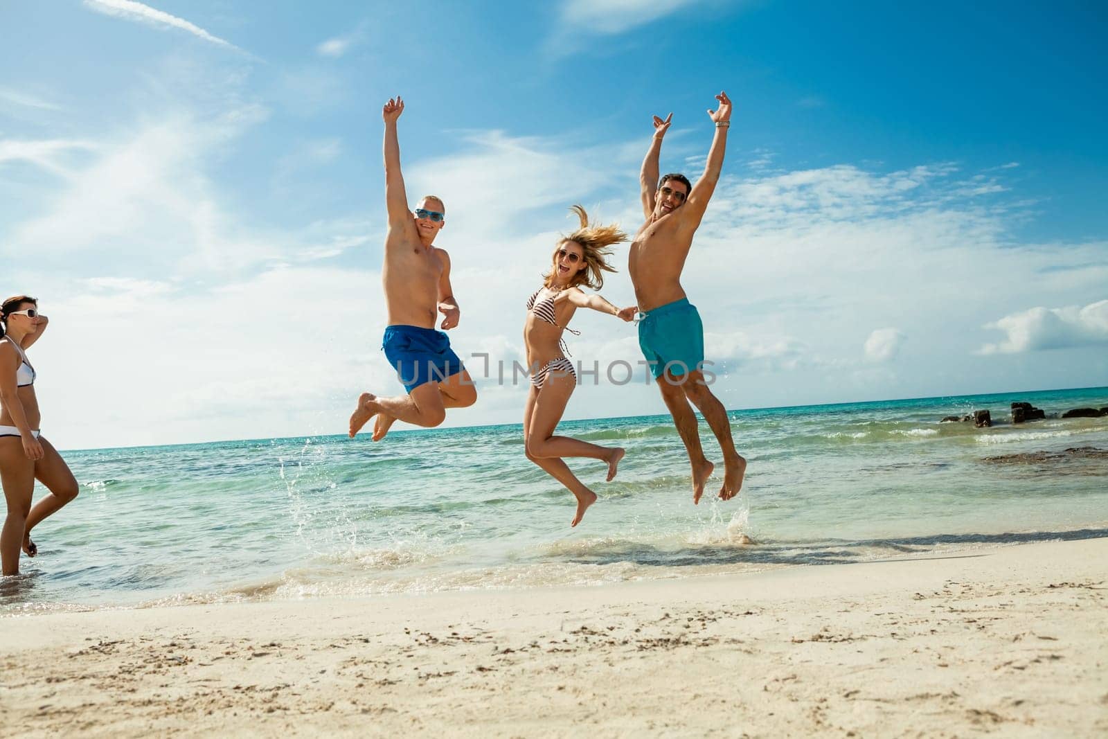 group of laughing young people on the beach in summer holiday leisure lifestyle