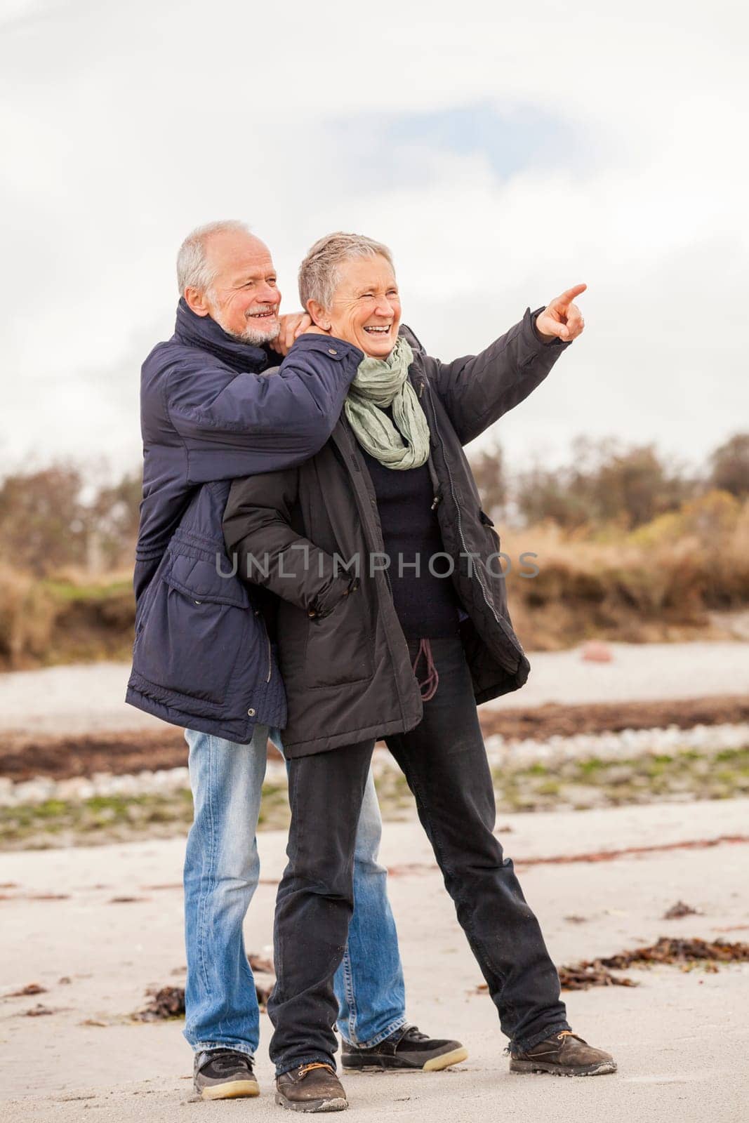older adult happy couple walks on the beach in autumn lifestyle happiness