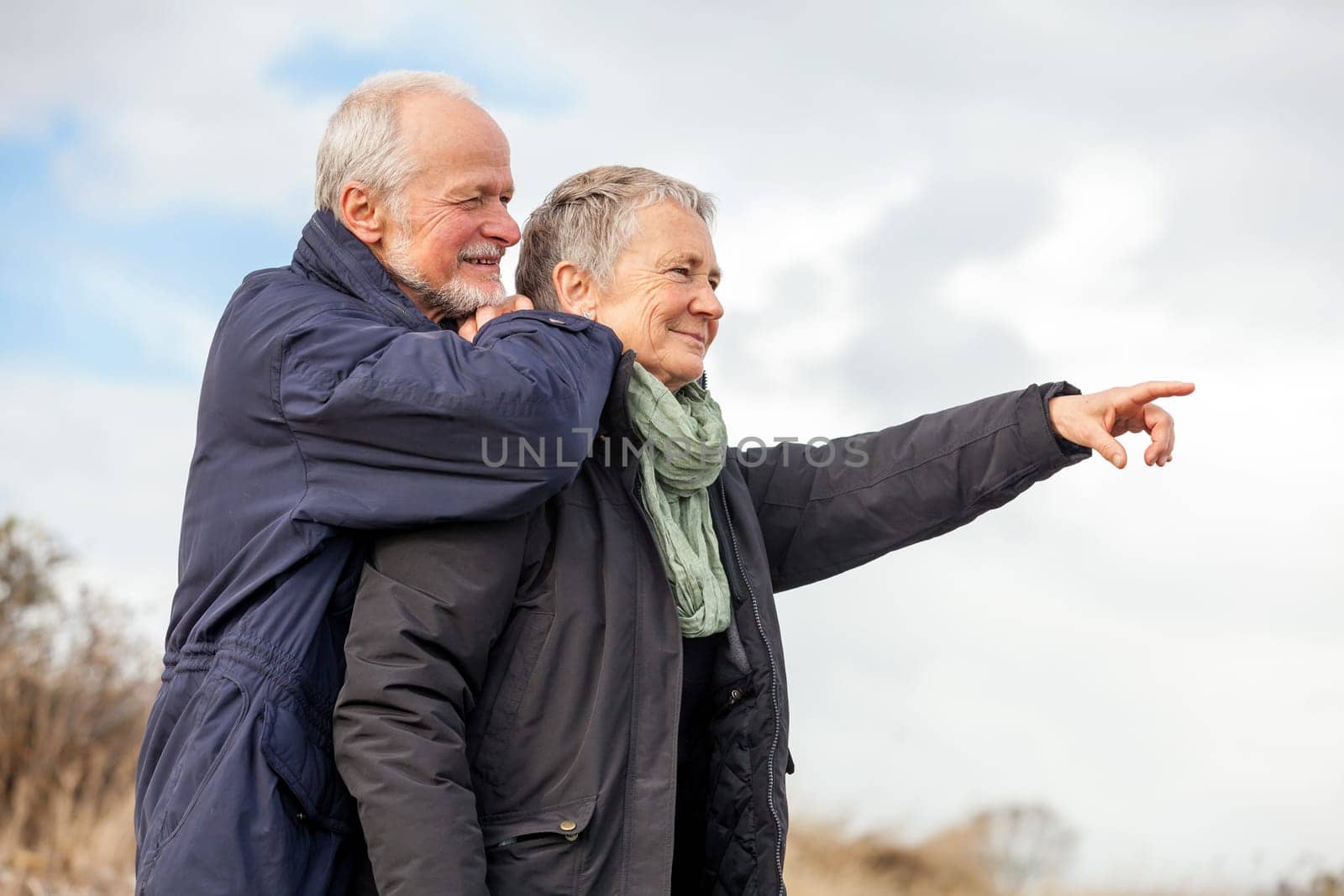 older adult happy couple walks on the beach in autumn lifestyle happiness