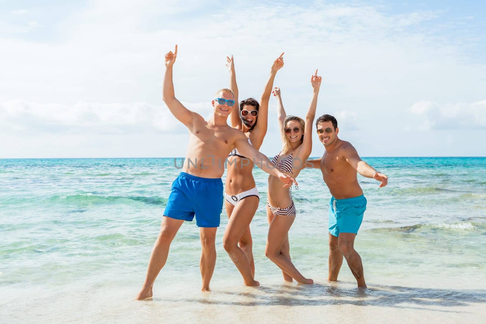 group of laughing young people on the beach in summer holiday leisure lifestyle