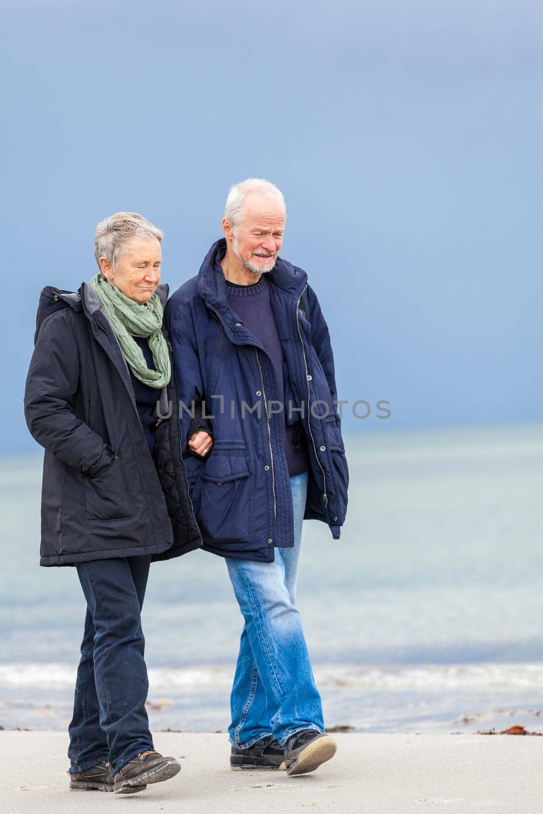 older adult happy couple walks on the beach in autumn lifestyle happiness