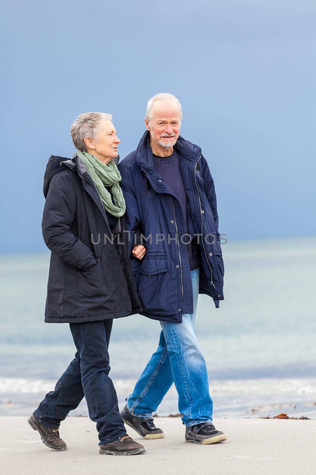 older adult happy couple walks on the beach in autumn lifestyle happiness