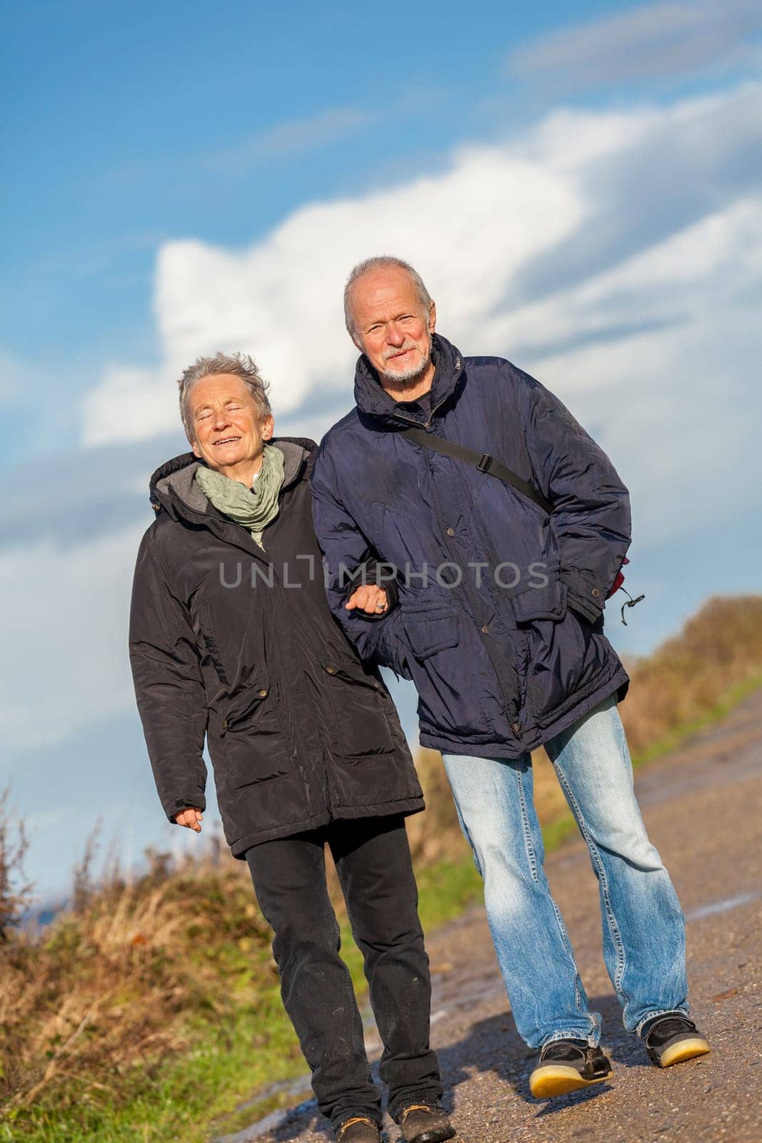 older happy couple makes a beach walk in autumn baltic sea landscape sea