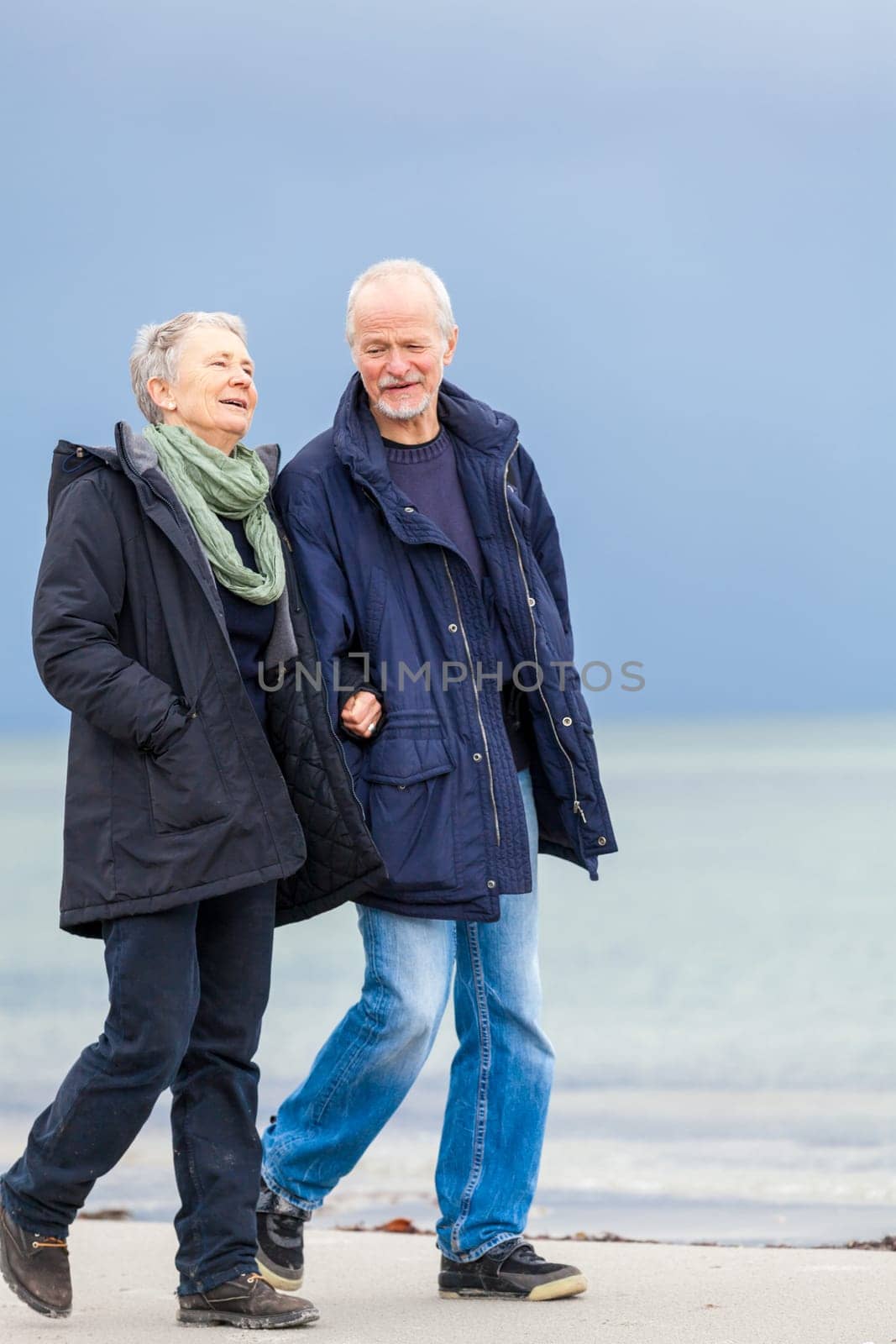 older adult happy couple walks on the beach in autumn lifestyle happiness