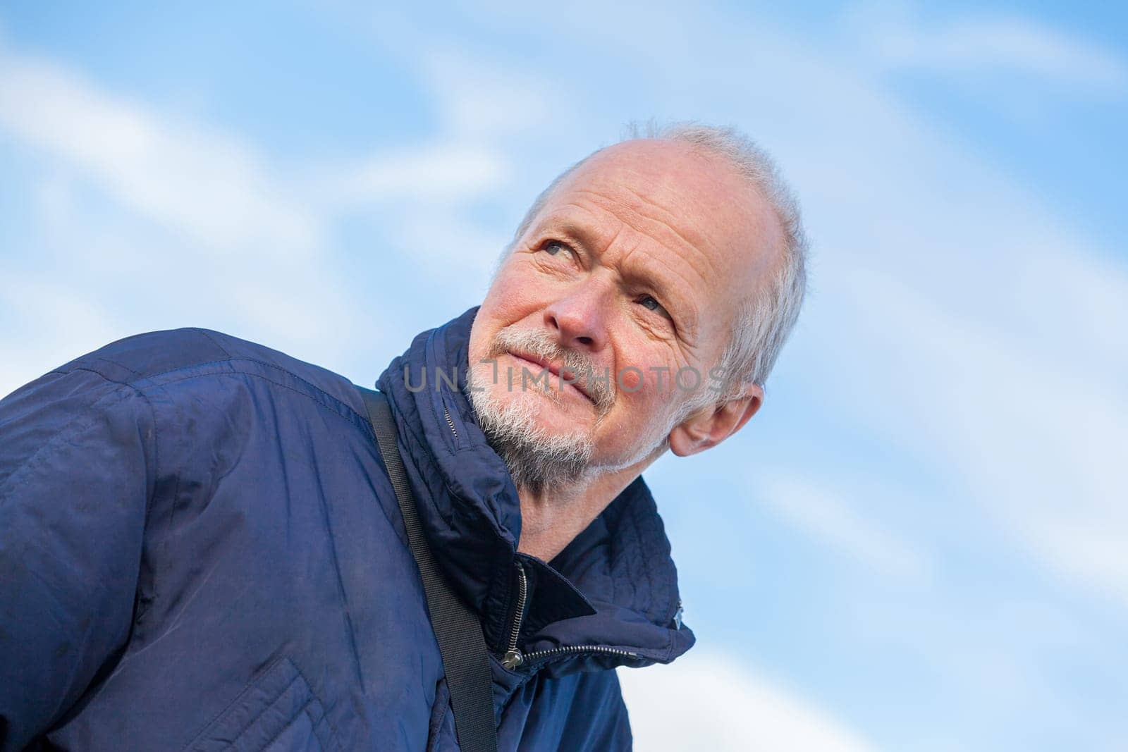 Adult older man senior living outdoors in front of blue sky portrait health
