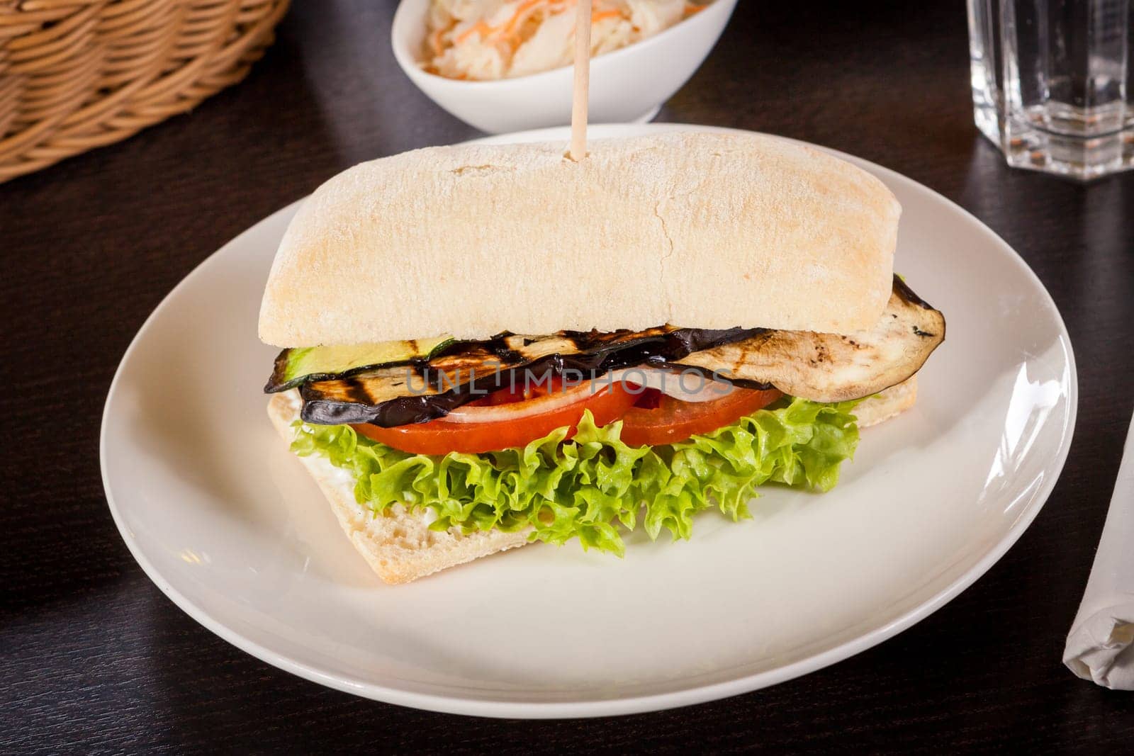 Vegetarian vegan hamburger with aubergine tomato and salad in a ciabatta bun