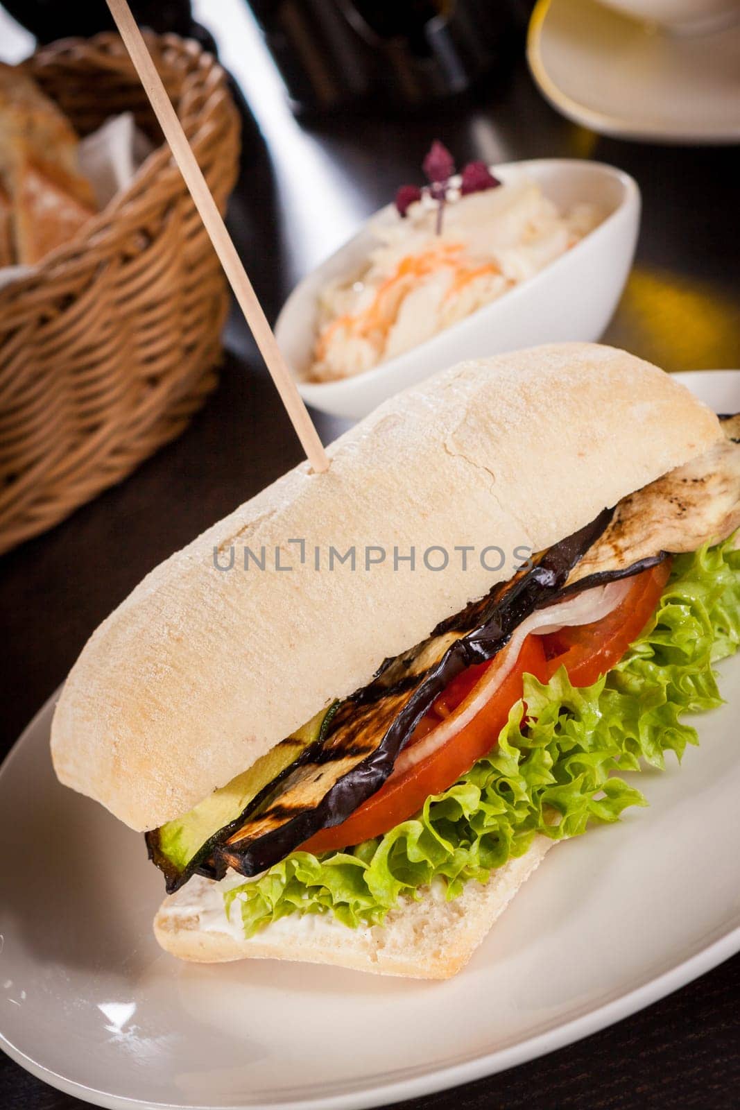 Vegetarian vegan hamburger with aubergine tomato and salad in a ciabatta bun