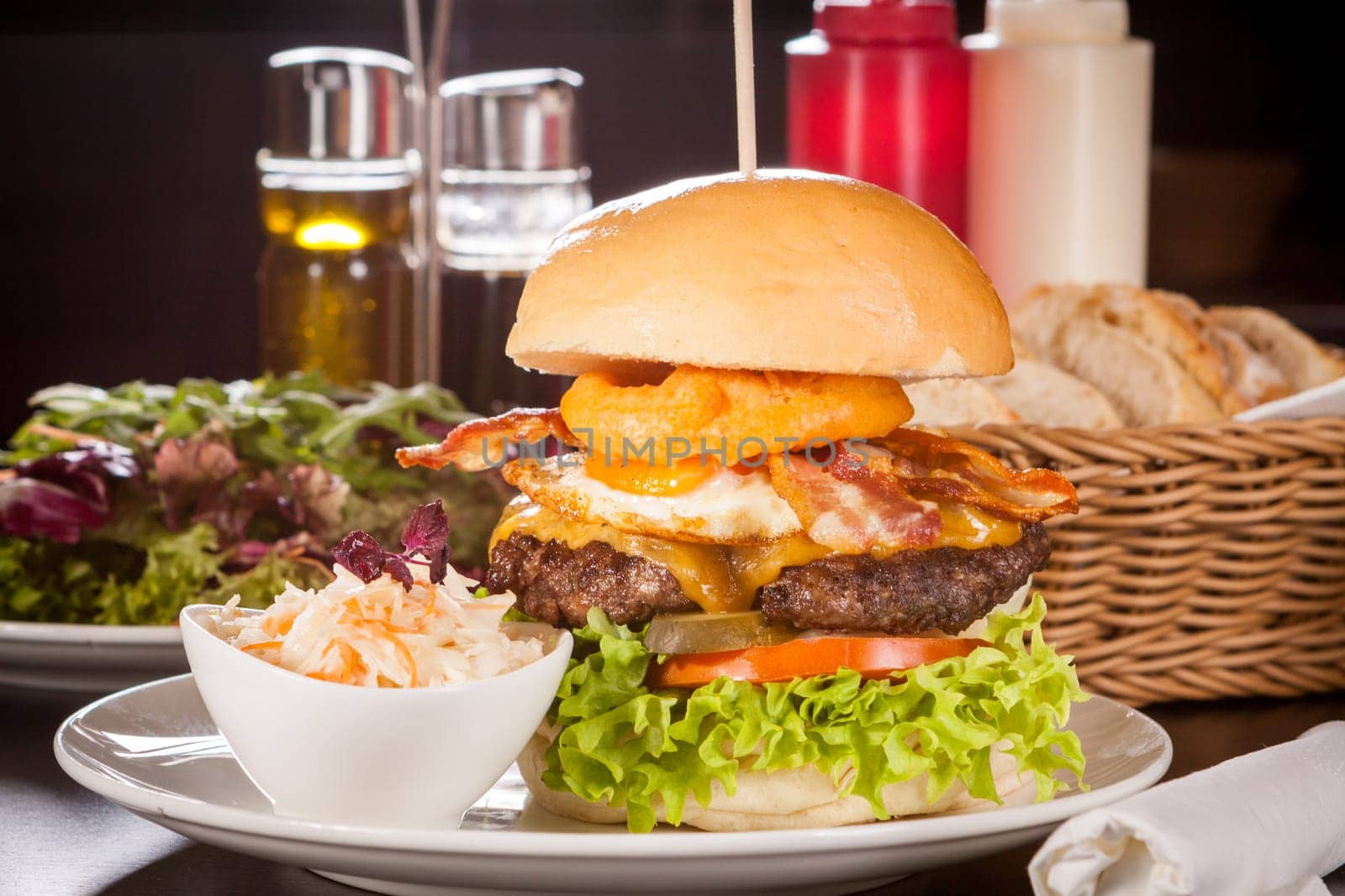 Delicious hamburger cheeseburger with bacon egg and salad on a plate