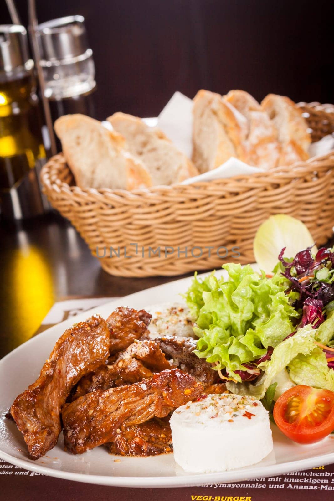 Fresh salad with fresh goat cheese and fried beef strips served on a plate