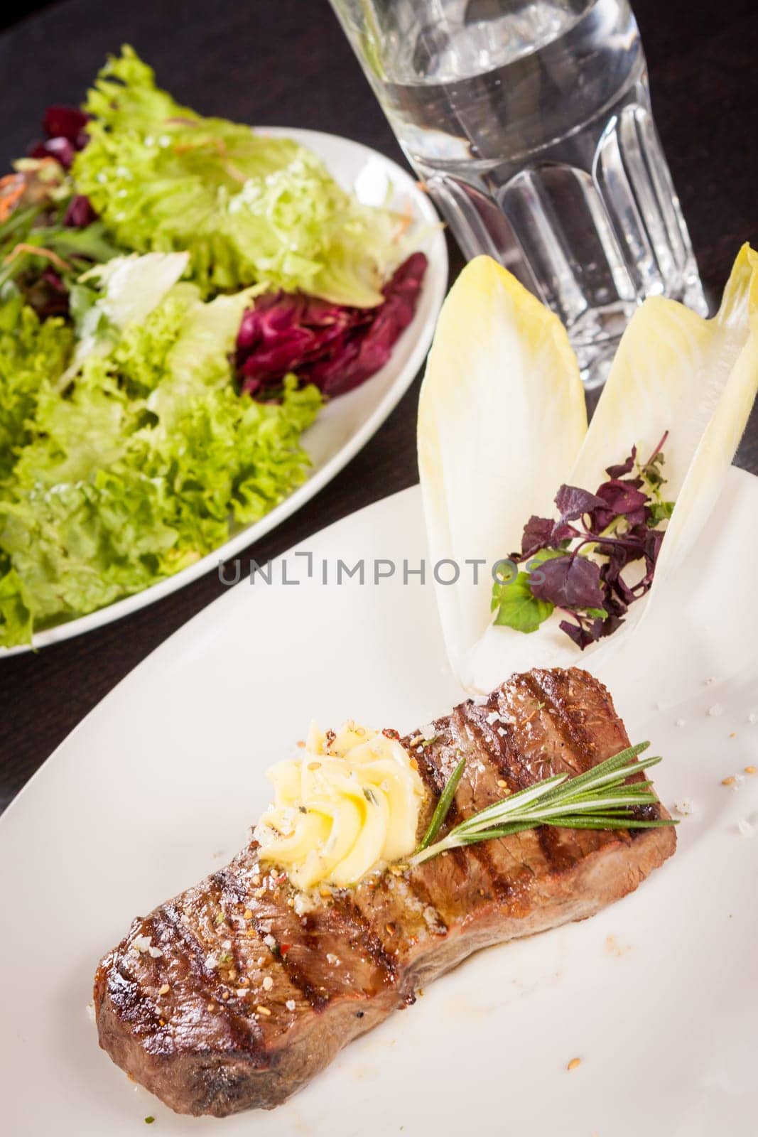 Succulent grilled beef fillet steak with homemade herb butter on a plate