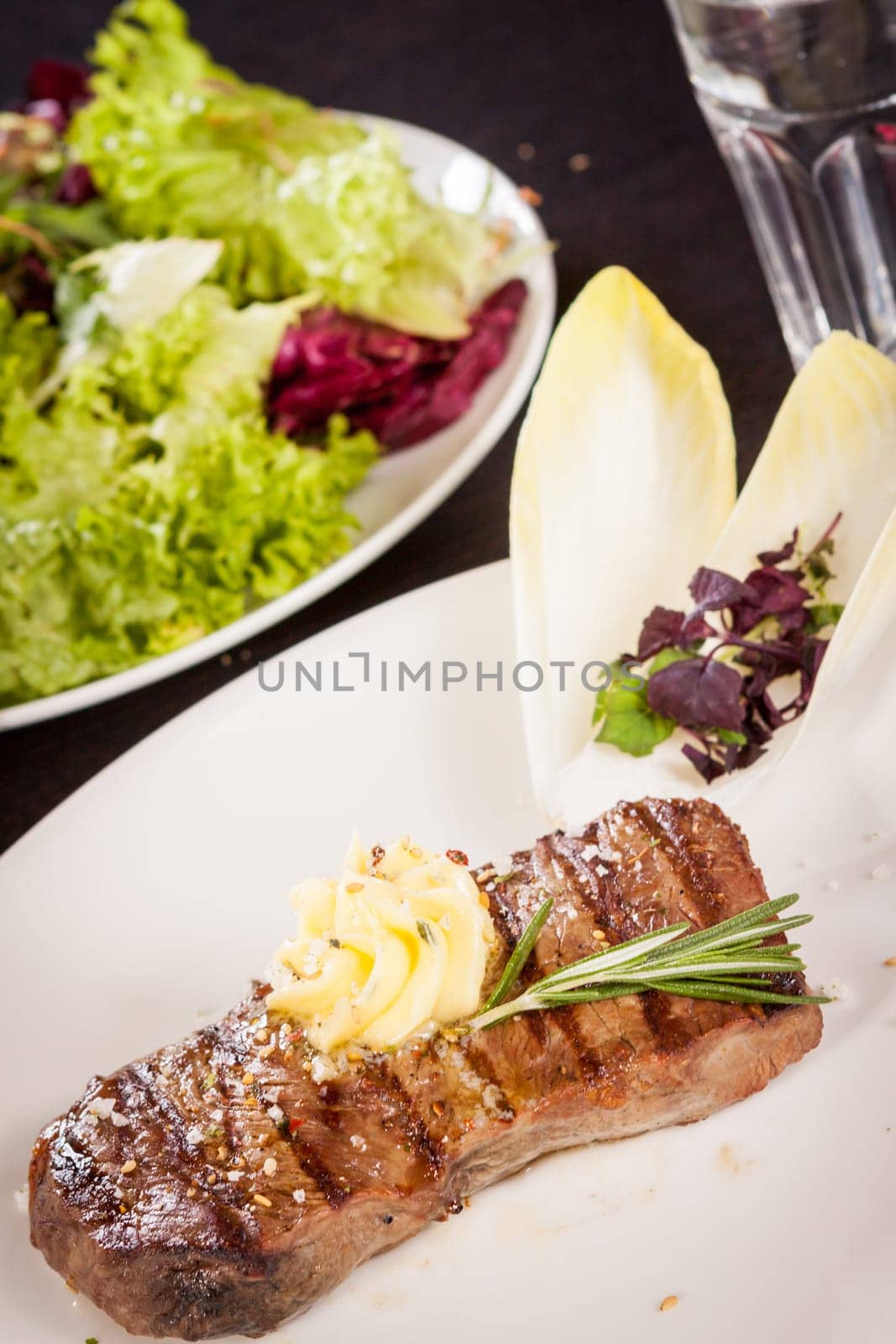 Succulent grilled beef fillet steak with homemade herb butter on a plate
