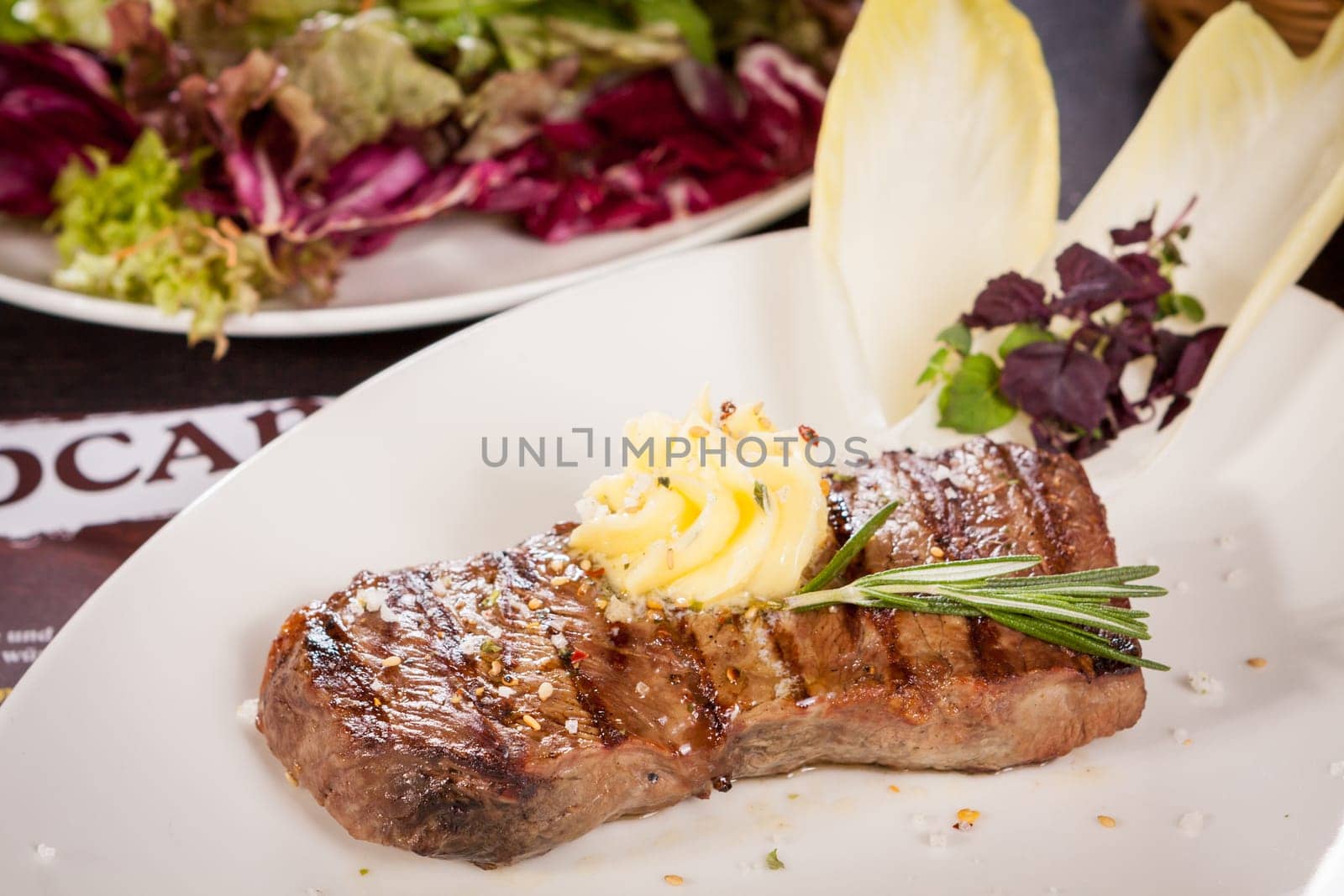 Succulent grilled beef fillet steak with homemade herb butter on a plate