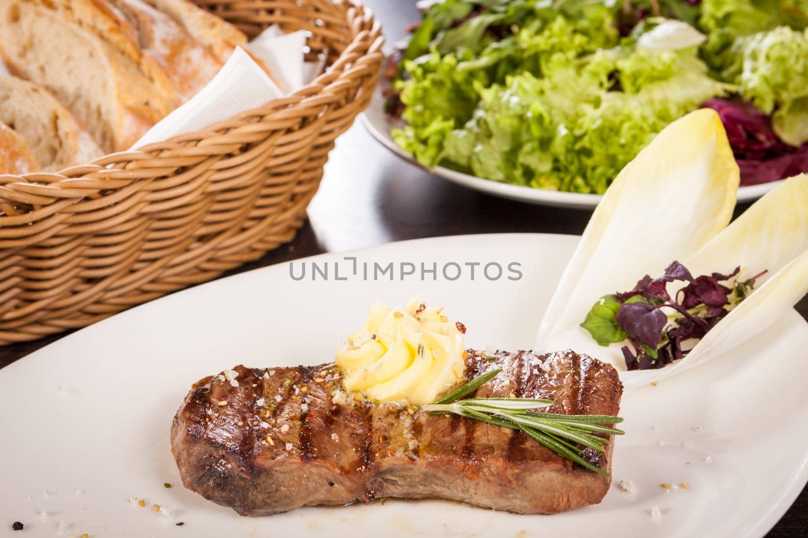 Succulent grilled beef fillet steak with homemade herb butter on a plate