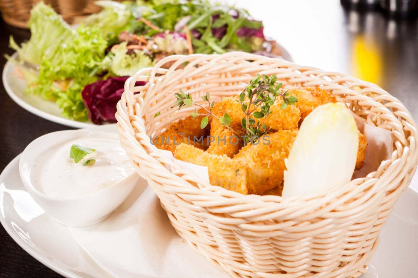 Fresh chicken flails and nuggets golden fried in a basket