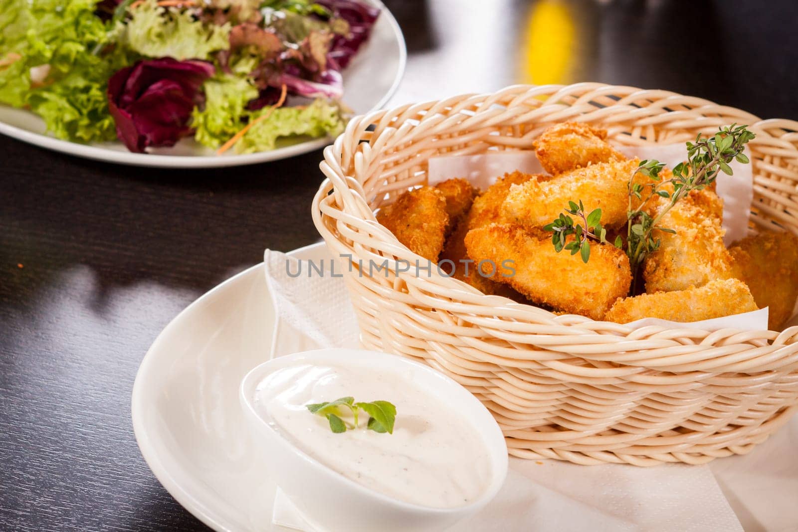Fresh chicken flails and nuggets golden fried in a basket