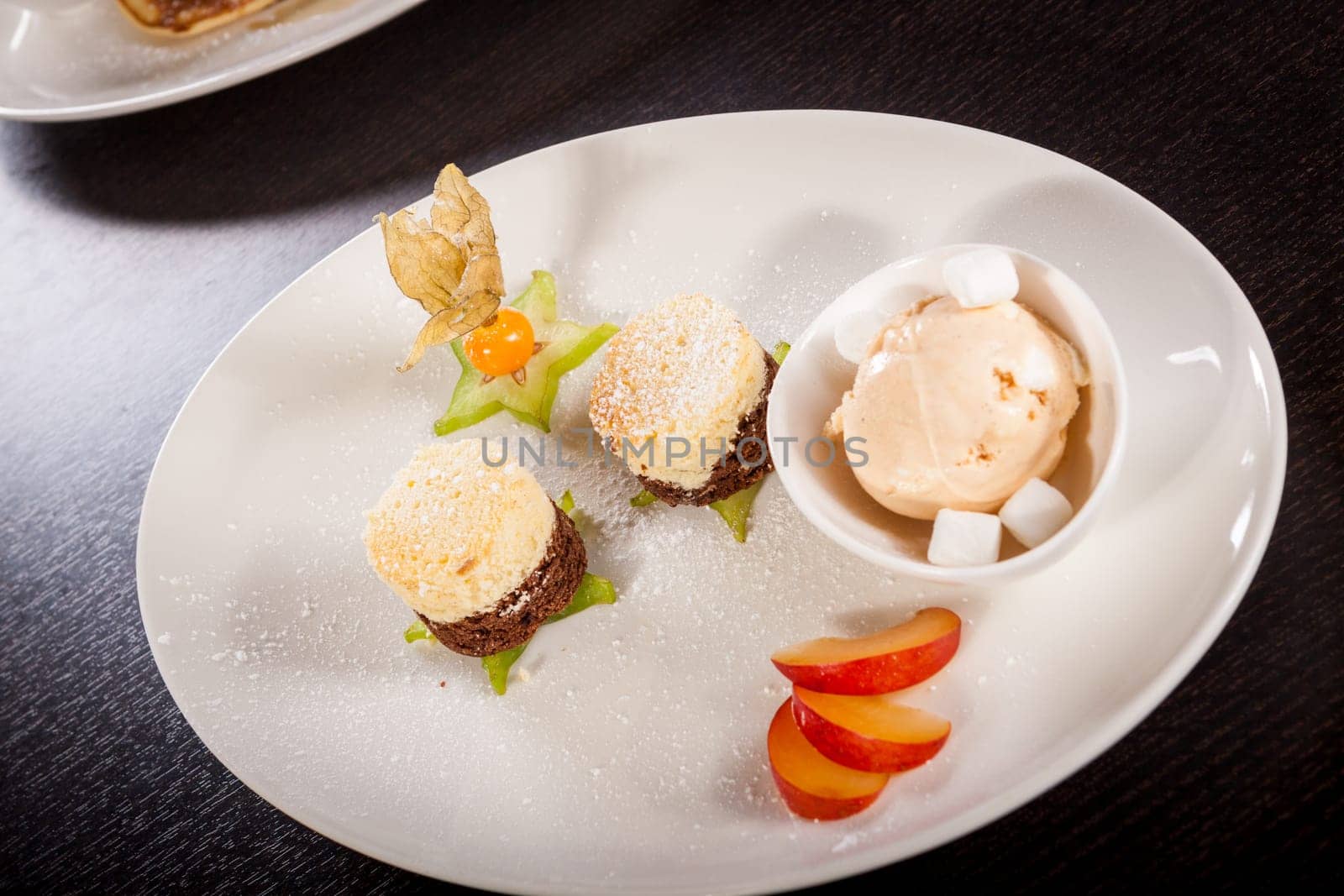 Brownie chocolate brownie with ice cream and plums prepared on a plate