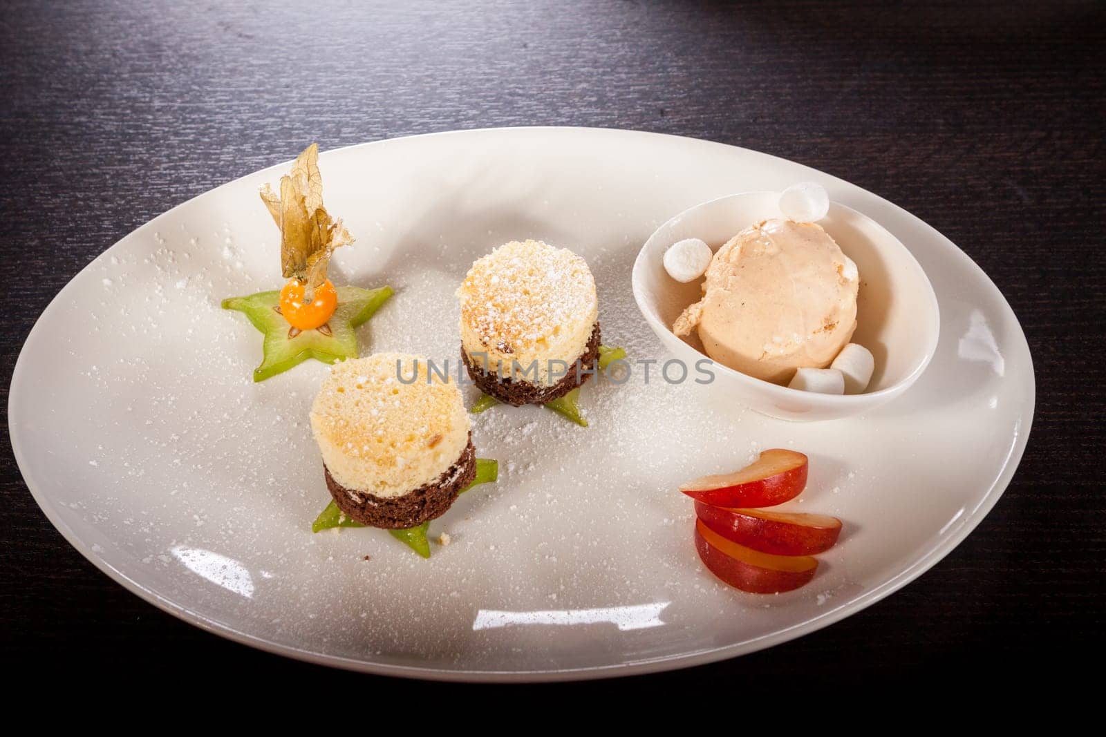 Brownie chocolate brownie with ice cream and plums prepared on a plate