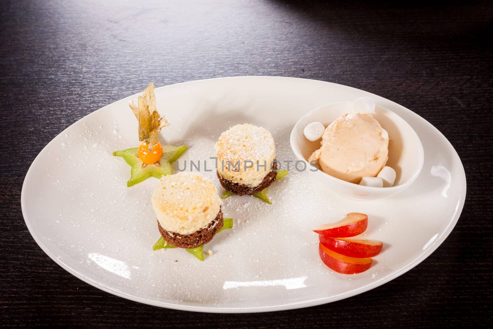 Brownie chocolate brownie with ice cream and plums prepared on a plate
